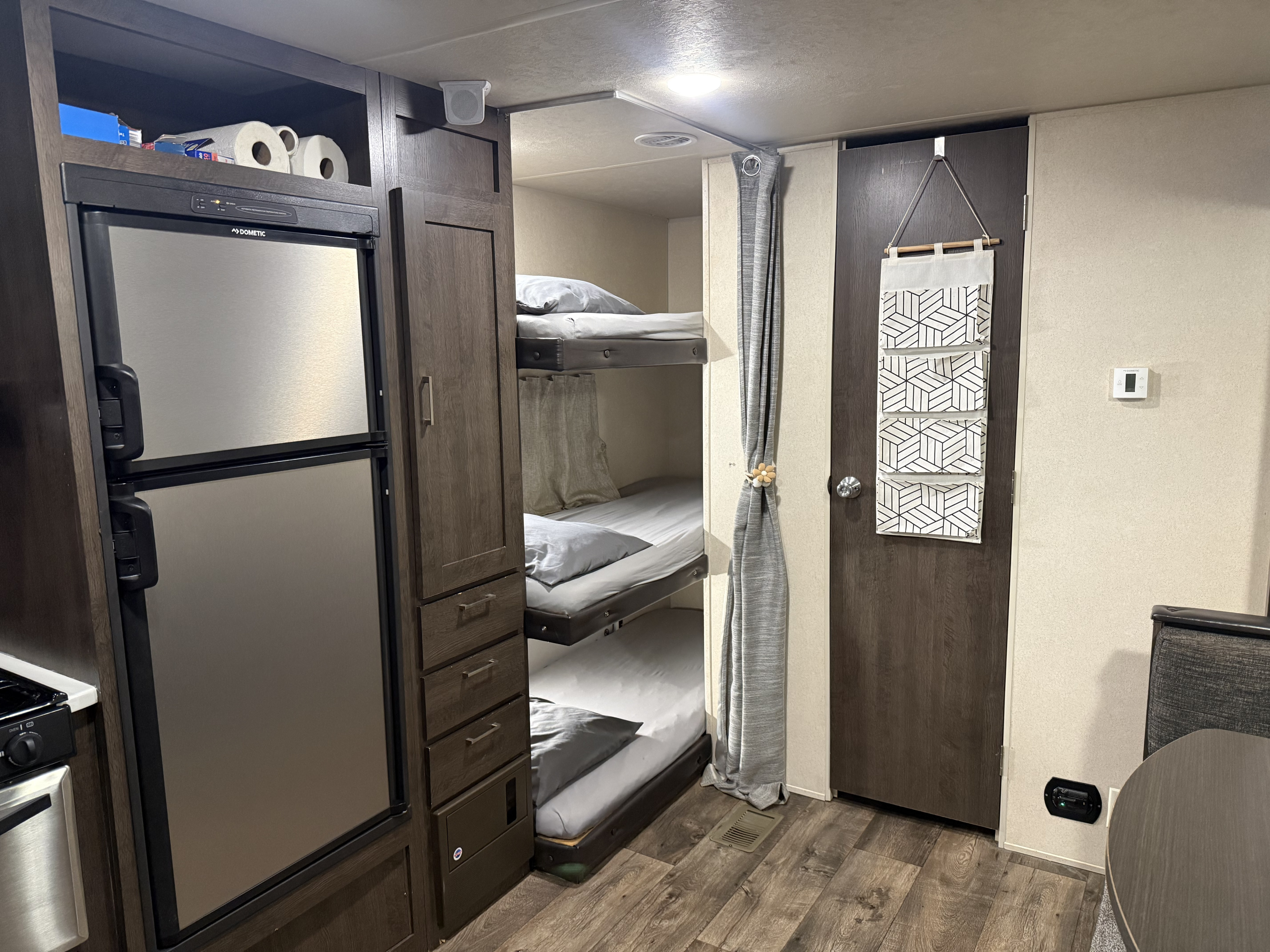 RV rental's functional interior features triple bunk beds, Dometic fridge, and ample storage for family trips.. Forest River Salem 2018