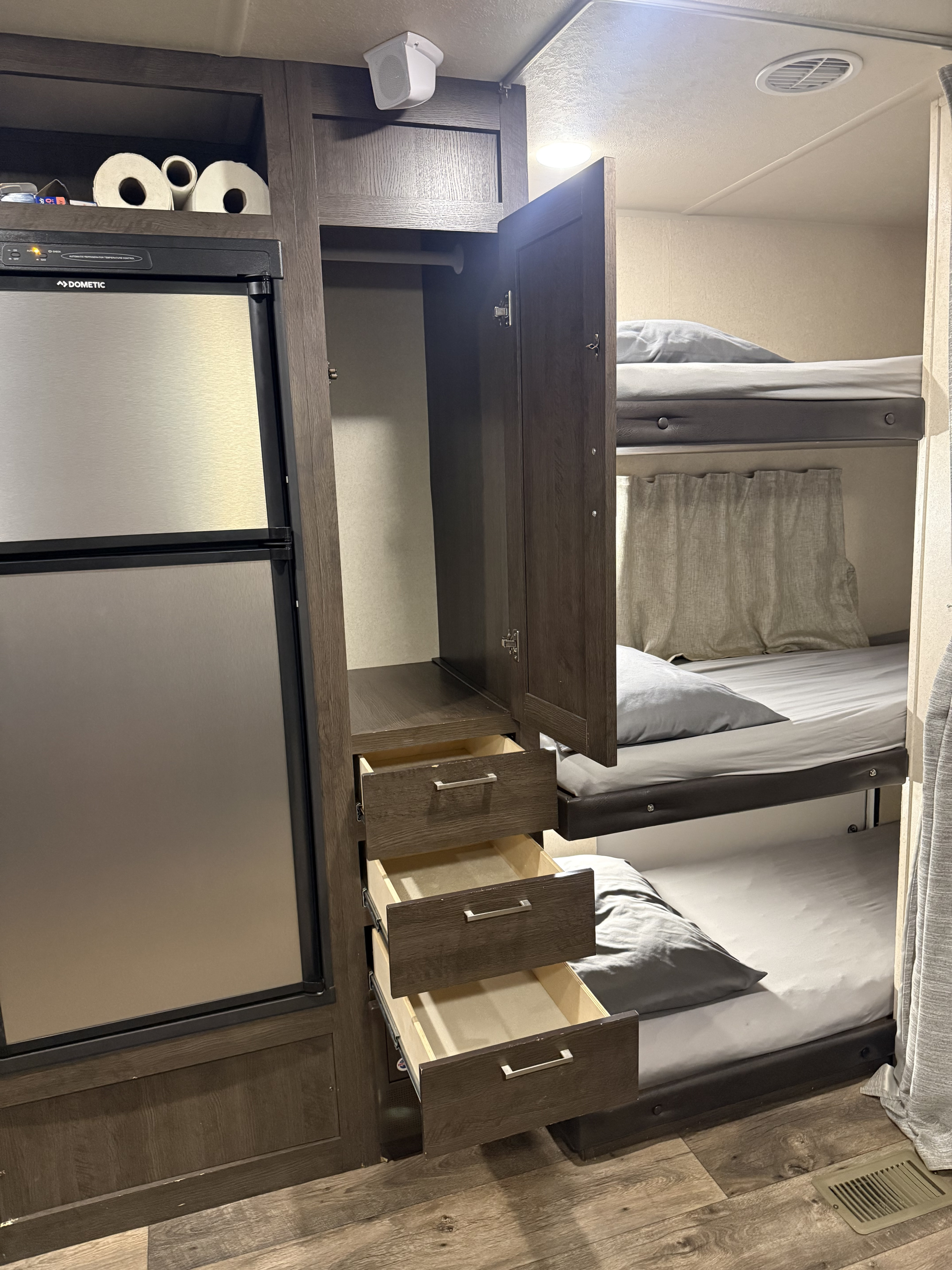 RV rental with bunk beds, a Dometic fridge, and an open wardrobe revealing storage drawers. Functional interior for travel.. Forest River Salem 2018