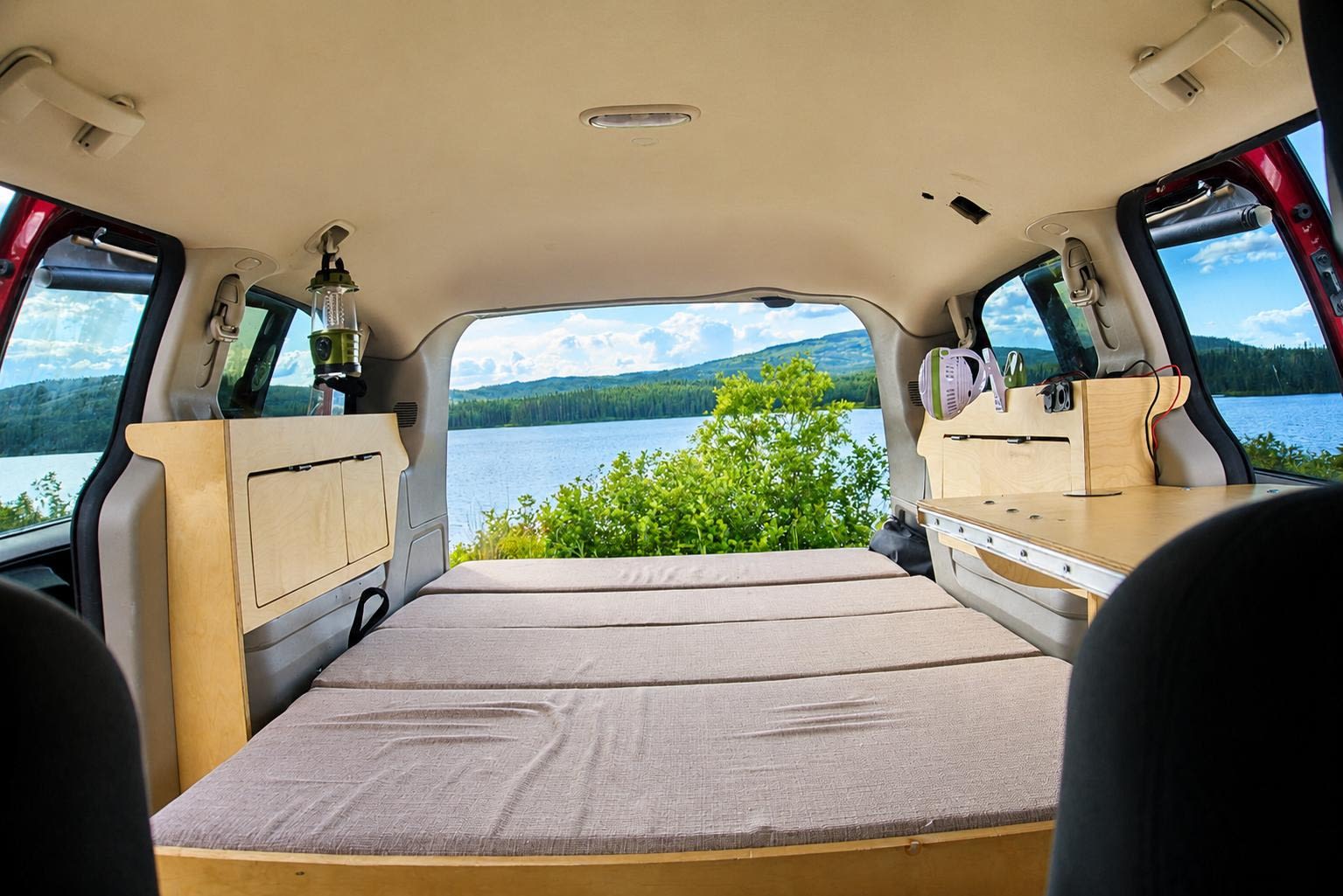 Custom RV rental minivan conversion: bed, storage, & scenic lake view for outdoor adventures.. Dodge Grand Caravan 2015