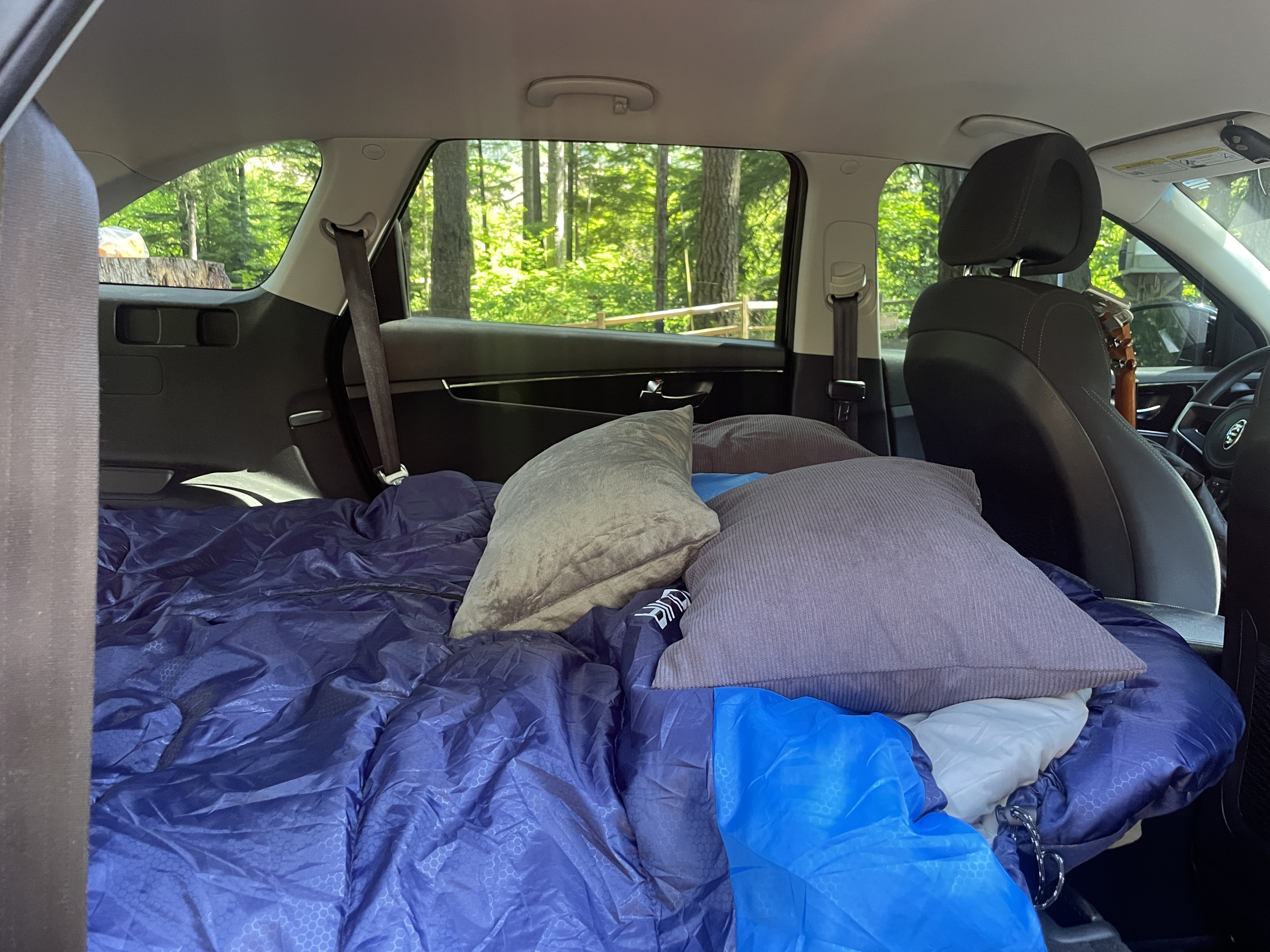 SUV transformed for car camping with a sleeping bag & pillows. Great alternative to an rv rental for forest adventures.. KIA Sorento 4X4 2017