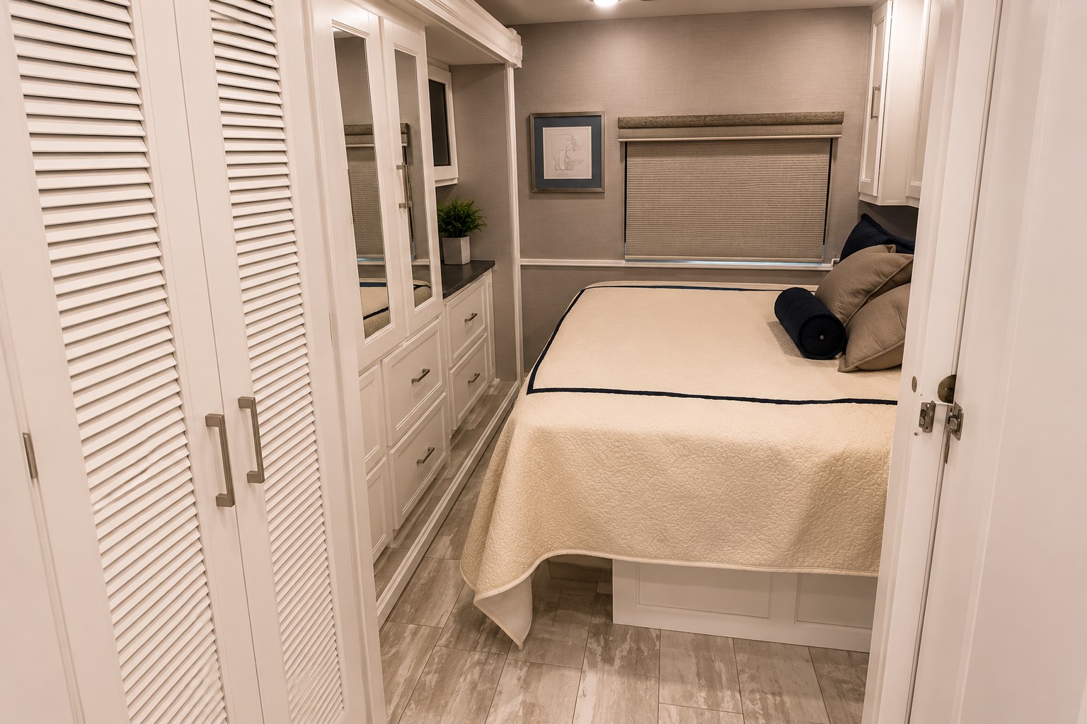 Inviting RV rental bedroom with a comfortable bed, mirrored storage cabinets, and louvered closet doors.. Forest River Coachmen Encore 2021