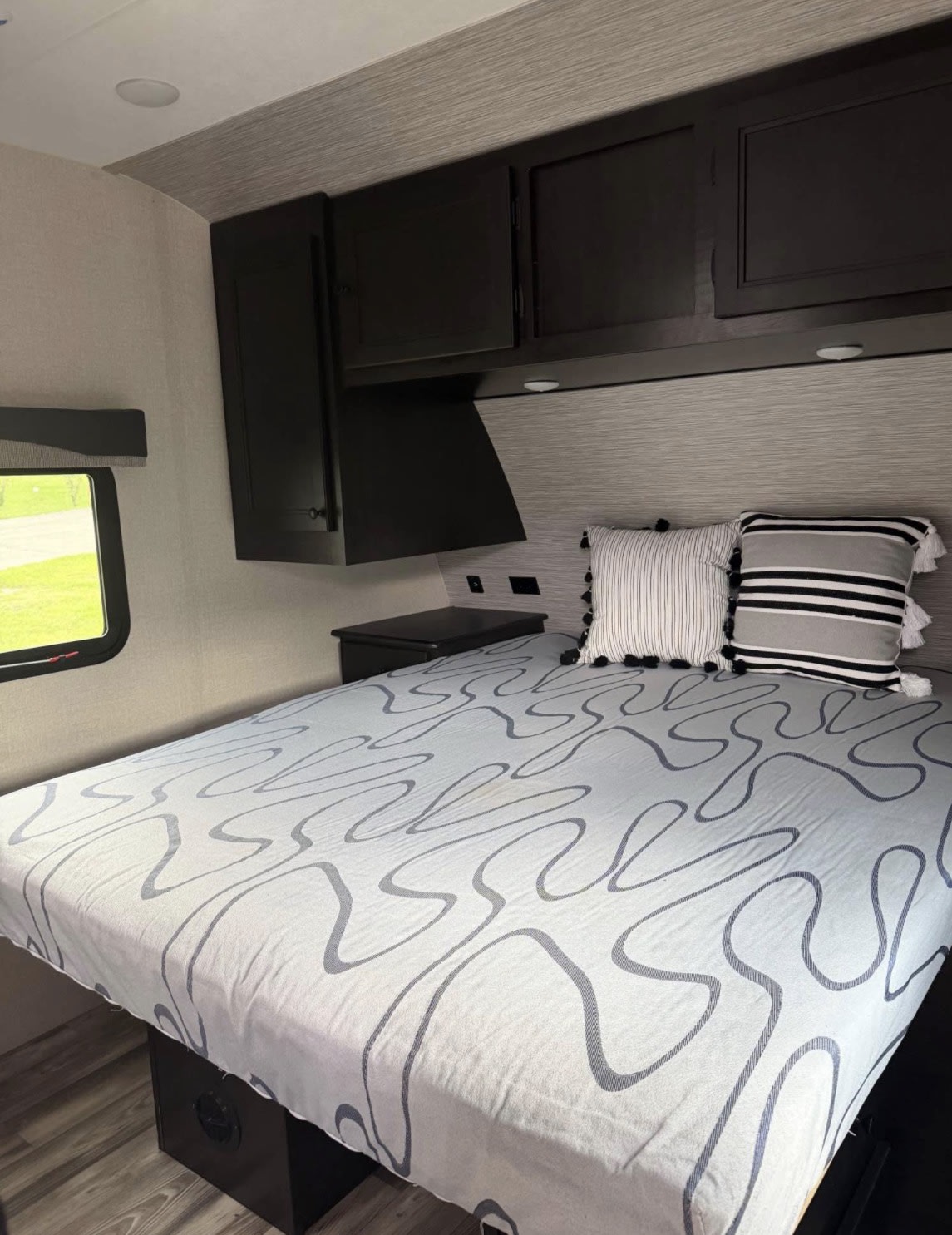 Cozy RV rental bedroom with a comfy bed, modern overhead cabinets, and a window for natural light. Perfect for travel.. Starcraft Super Lite 2022