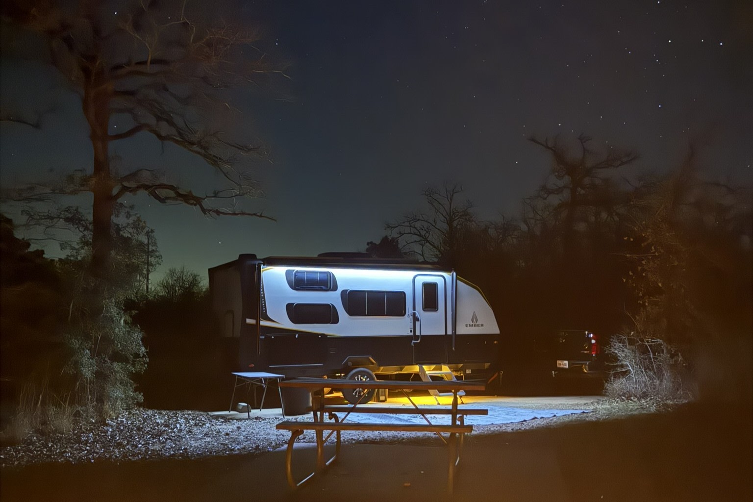 The Ember glowing beneath the stars at a nighttime campsite