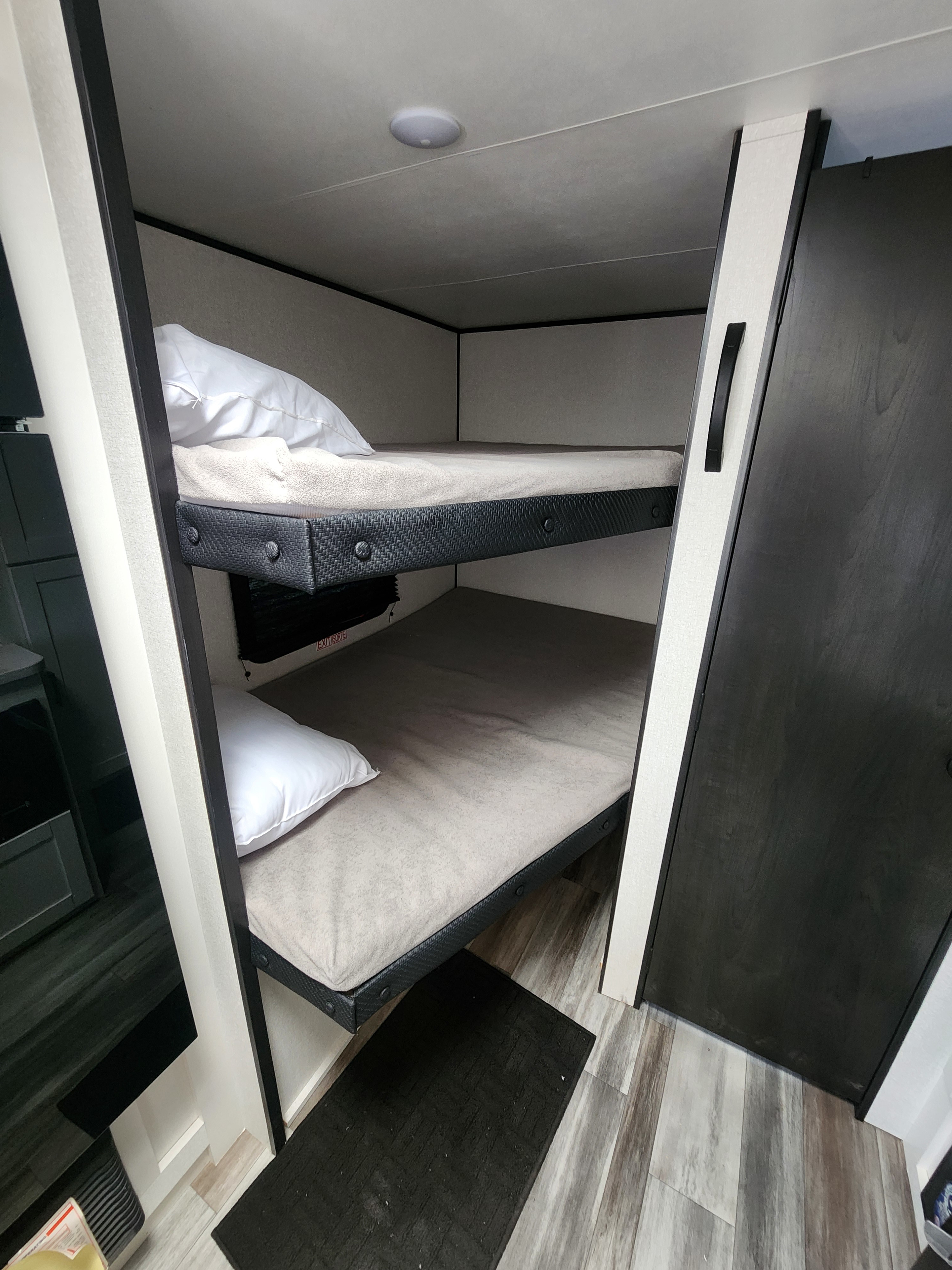 Two stacked bunk beds with mattresses and pillows inside a compact RV rental, offering efficient sleeping.. Jayco Jay Flight SLX Sport Edition 2026