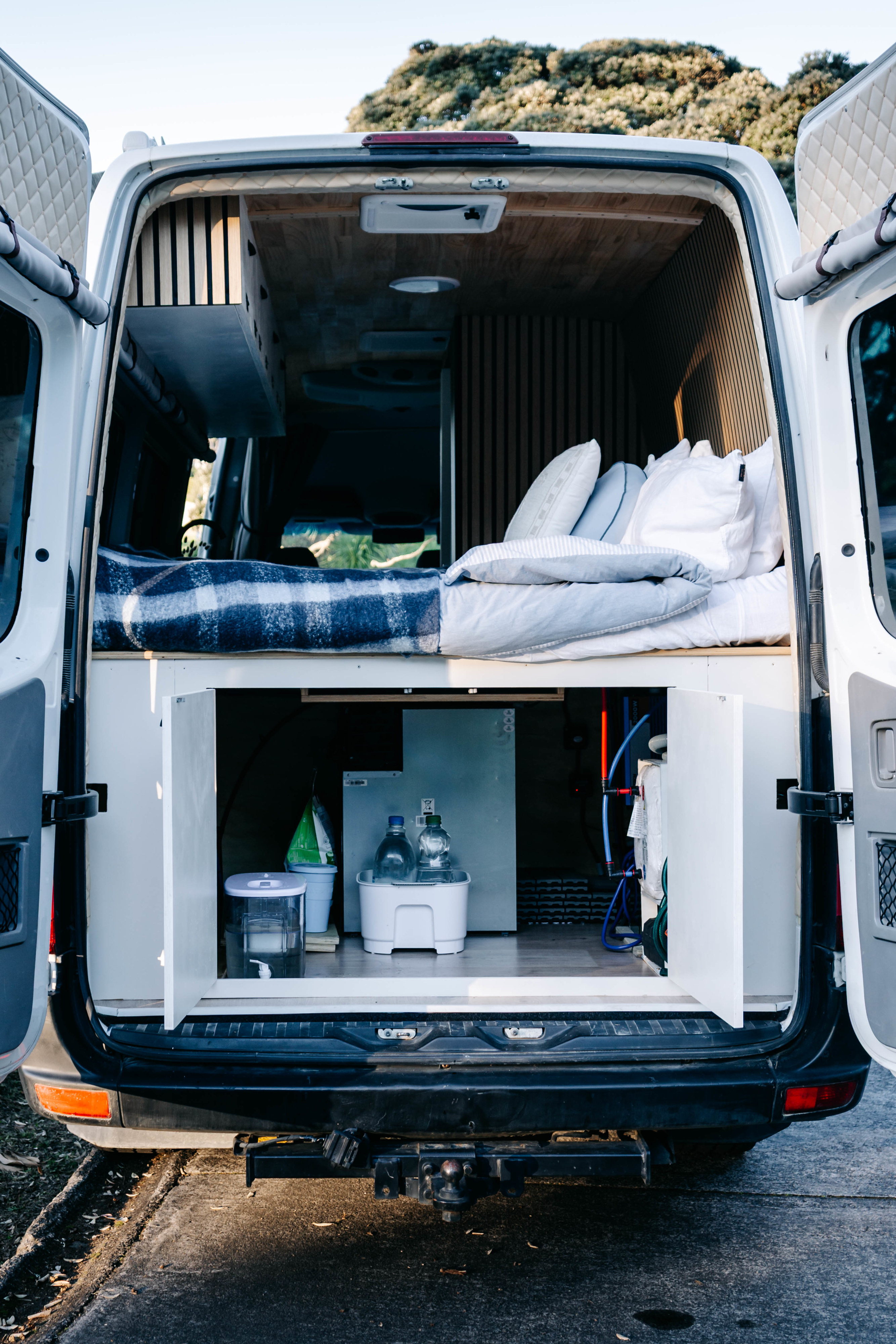 Custom-built RV rental interior with a cozy bed, ample storage, and smart organization for your van life adventures.. Mercedes Sprinter 2010