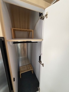 Inside an RV rental: compact wardrobe with hanging rod, shelves, & storage.. Airstream Flying Cloud 2025