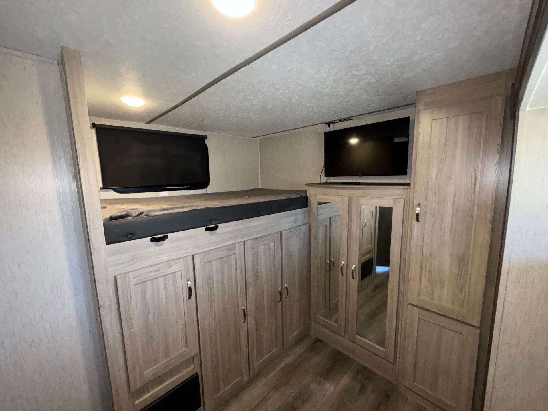 RV rental: bunk bed with window, below-bed storage cabinets, TV, and a mirrored wardrobe. Functional and organized.. Coachmen Freedom Express 320BHDSLE 2021