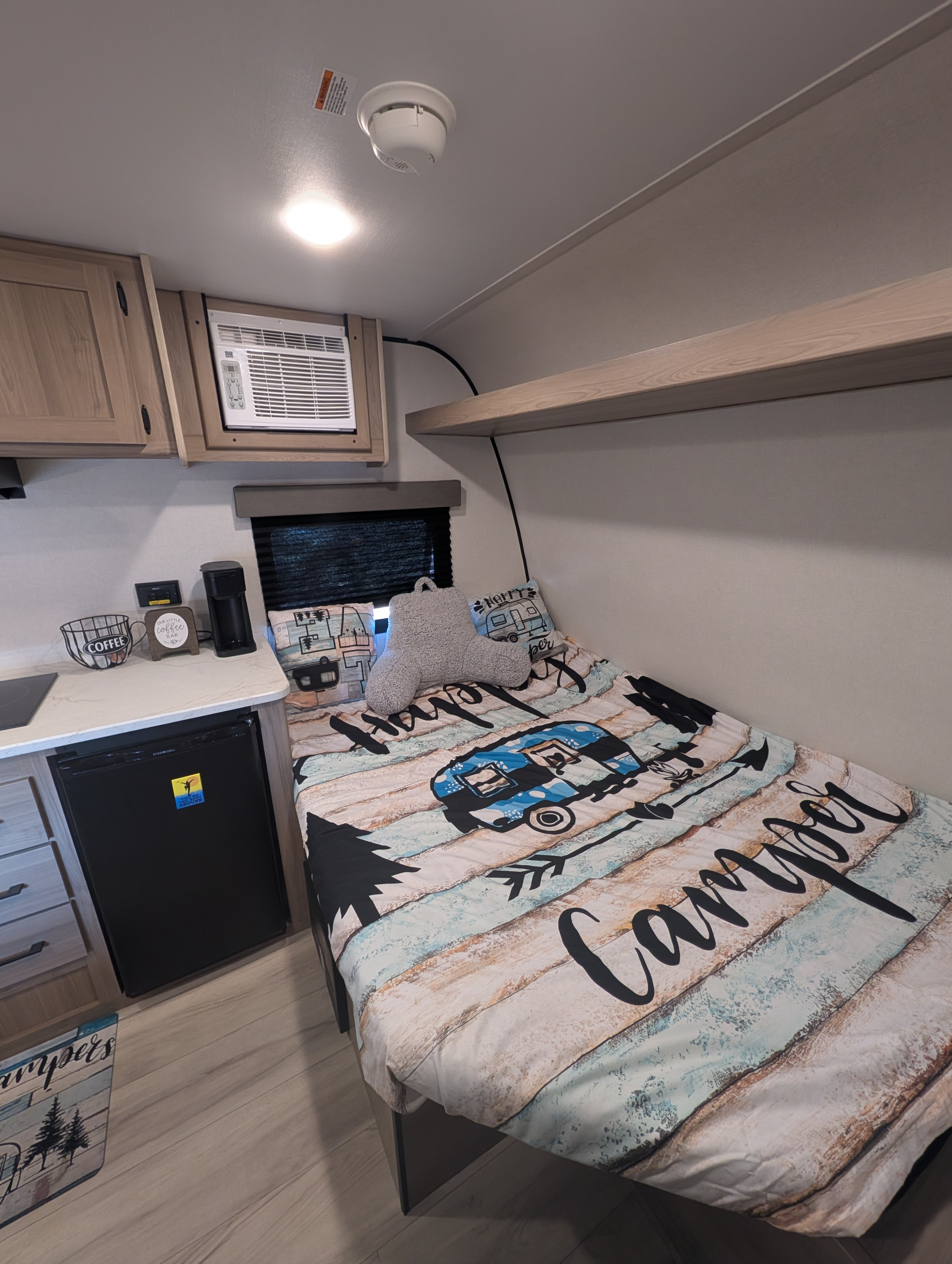 Cozy rv rental interior featuring a "Camper" bed, compact kitchen with fridge & coffee maker, and practical overhead storage.. Keystone RV Coleman 2025