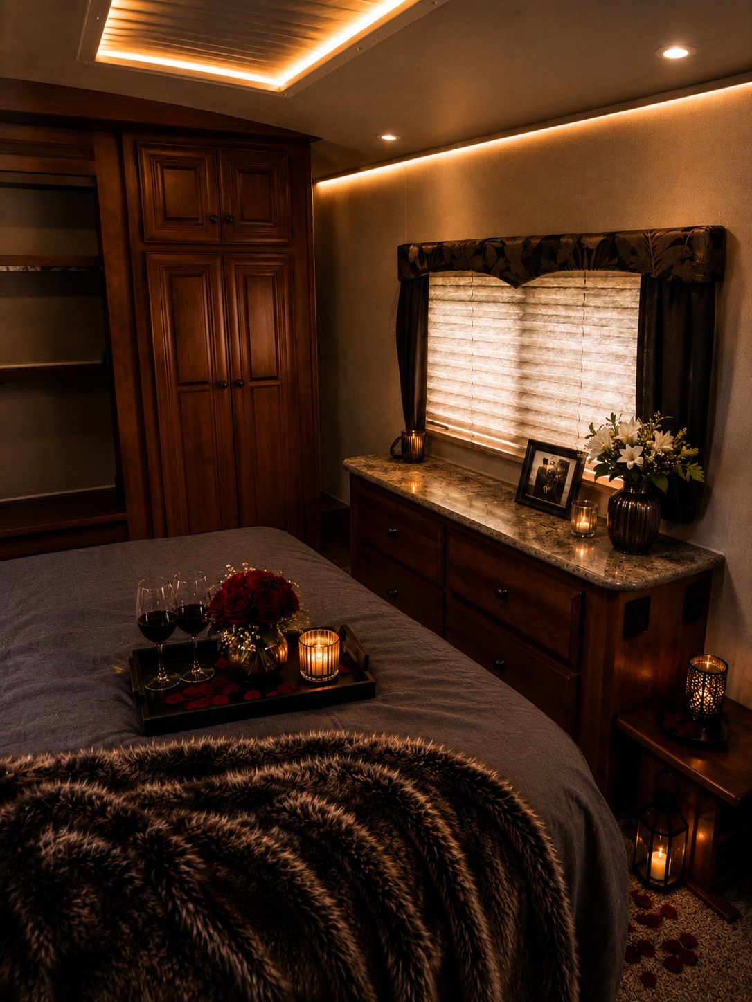 Luxury RV rental bedroom featuring a bed with a tray of wine, roses, and candles, bathed in warm ambient light.. Arctic Fox Silver Fox Edition 2015