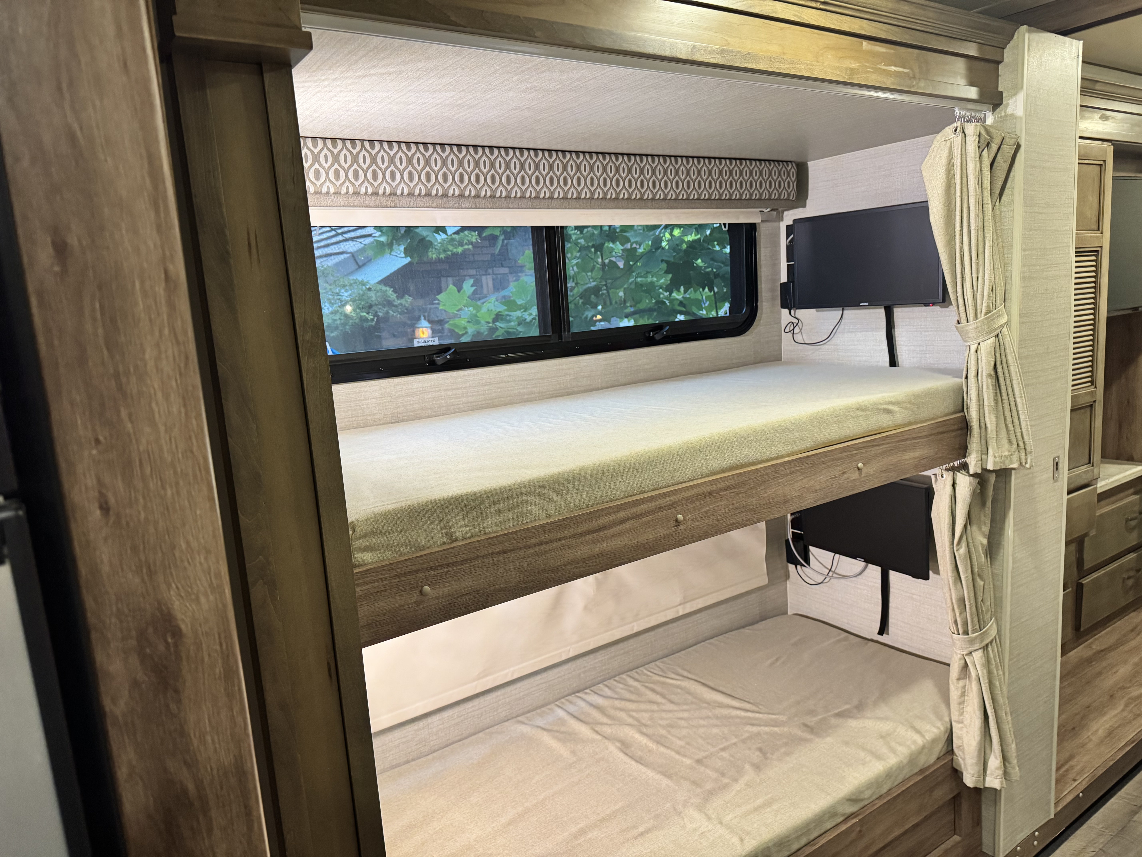 RV rental bunk beds with personal TVs, window views, and privacy curtains, perfect for travel.. Jayco Precept 2019