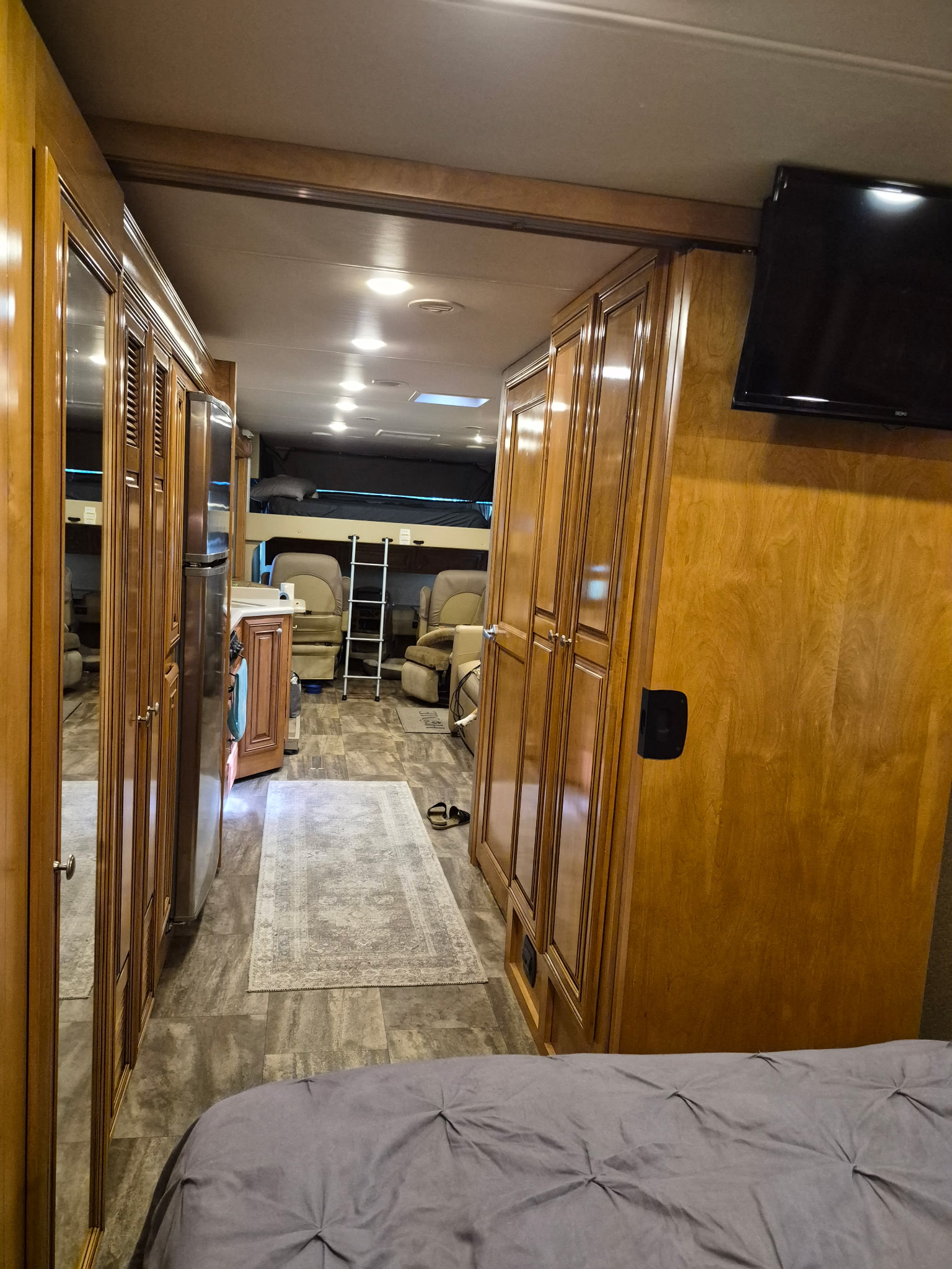 This RV rental interior features a galley kitchen, hallway to bunk beds & seating area. Ample storage & TV. Great for trips!. Thor Palazzo 2018