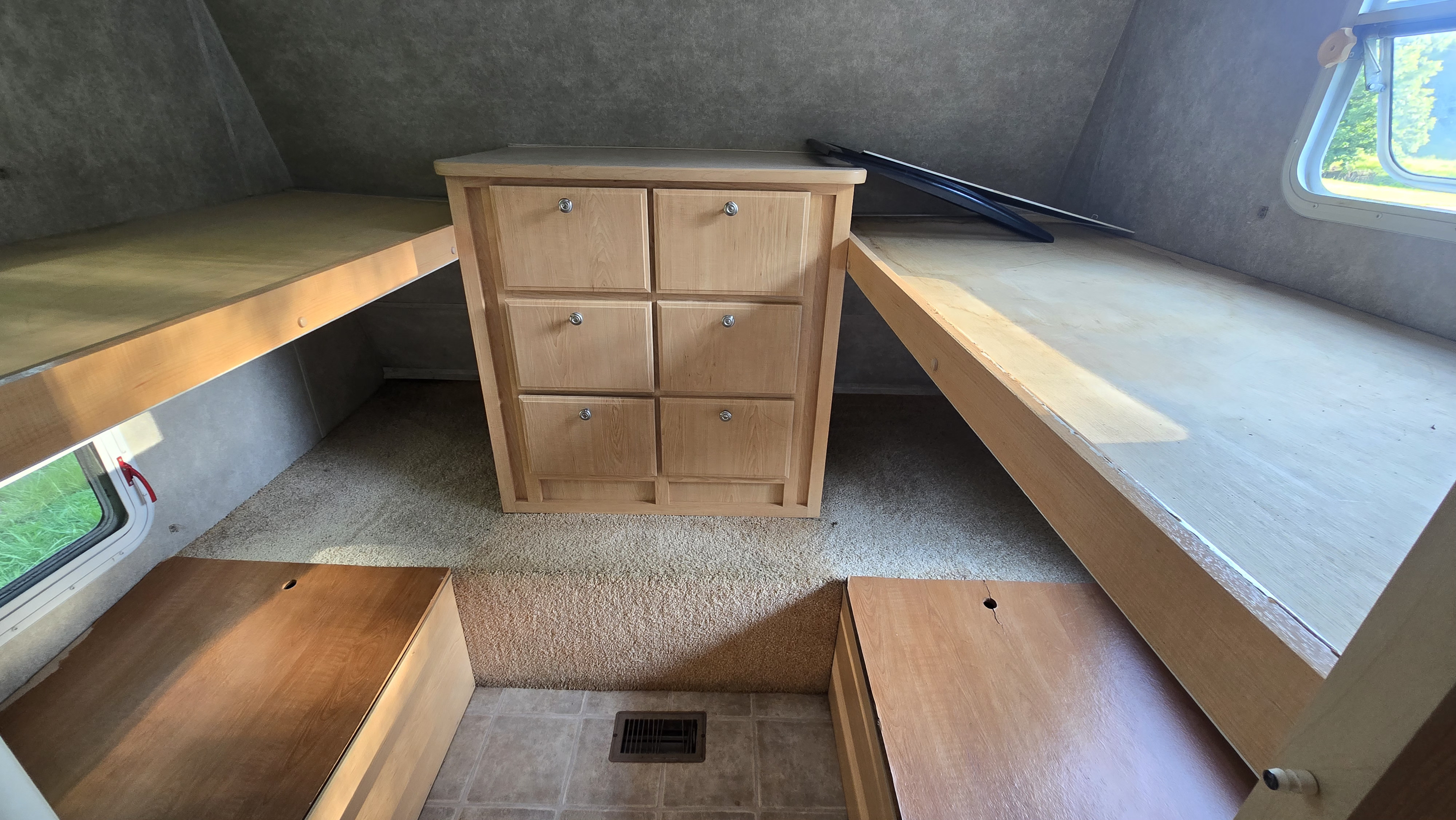 RV rental interior featuring bunk beds, a central dresser with six drawers, and two floor storage compartments.. Starcraft Homestead Settler 2004