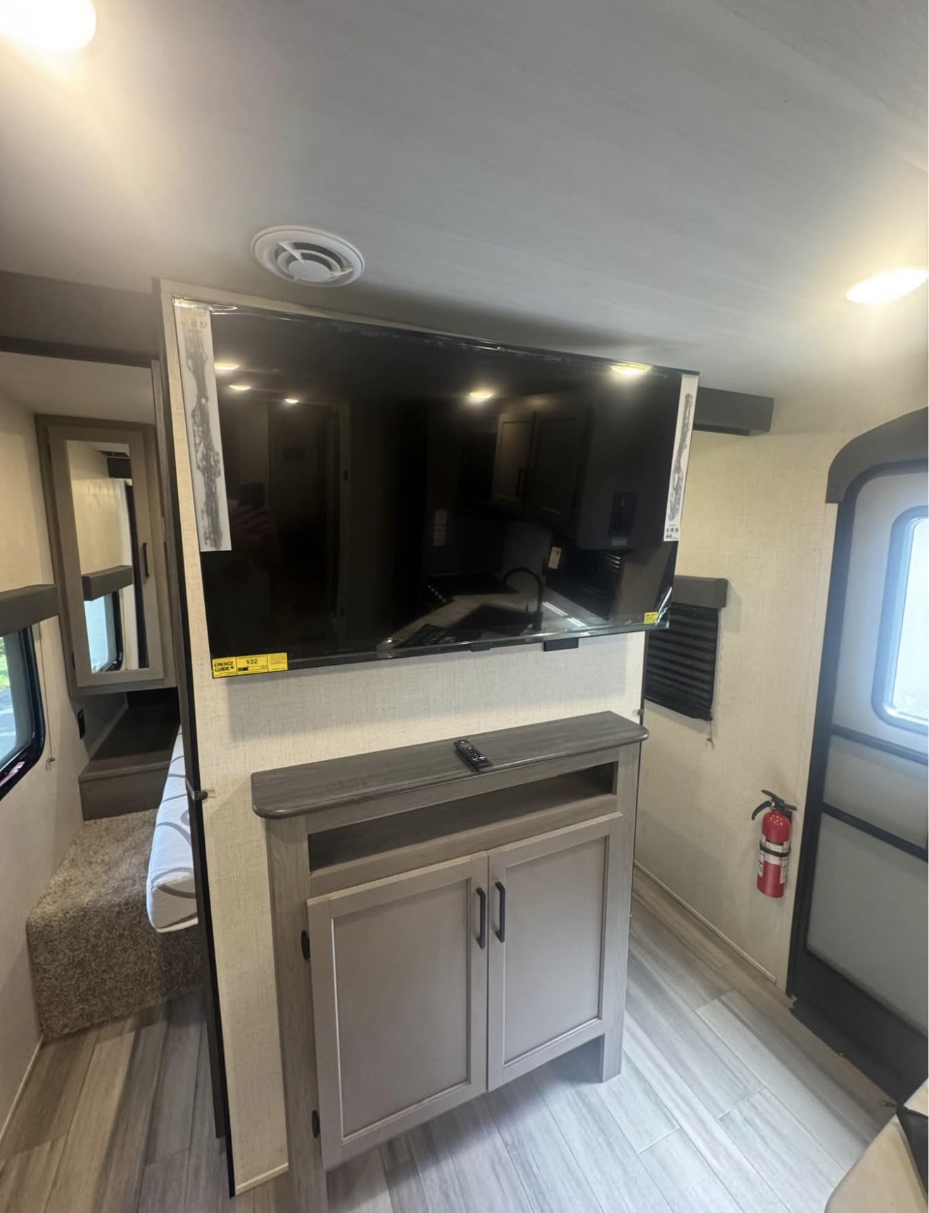 RV rental: Modern camper interior featuring a TV, storage, adjacent compact bedroom, and fire extinguisher near the door.. Keystone RV Hideout 2024