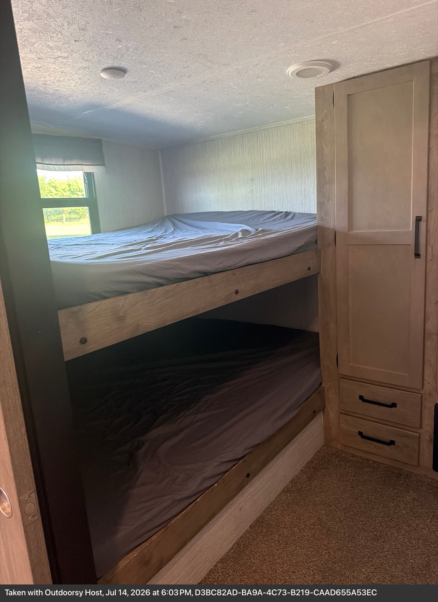 Inside this RV rental: two bunk beds with gray bedding, a window view, and built-in storage.. Forest River Palomino Puma 2021