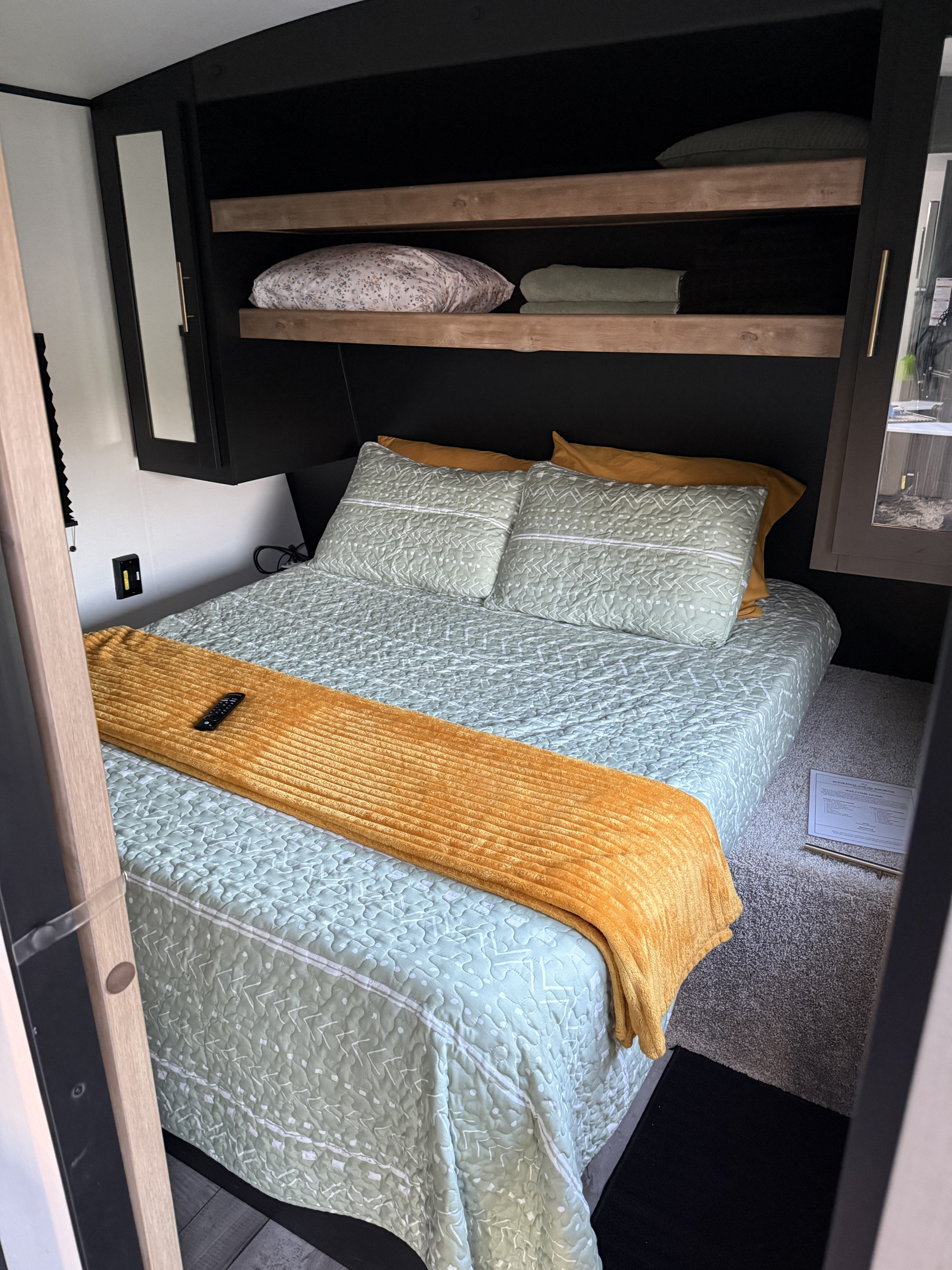Cozy RV rental bedroom with a modern design, queen bed, smart storage, and earthy decor for a comfortable stay.. Keystone RV Springdale 2022