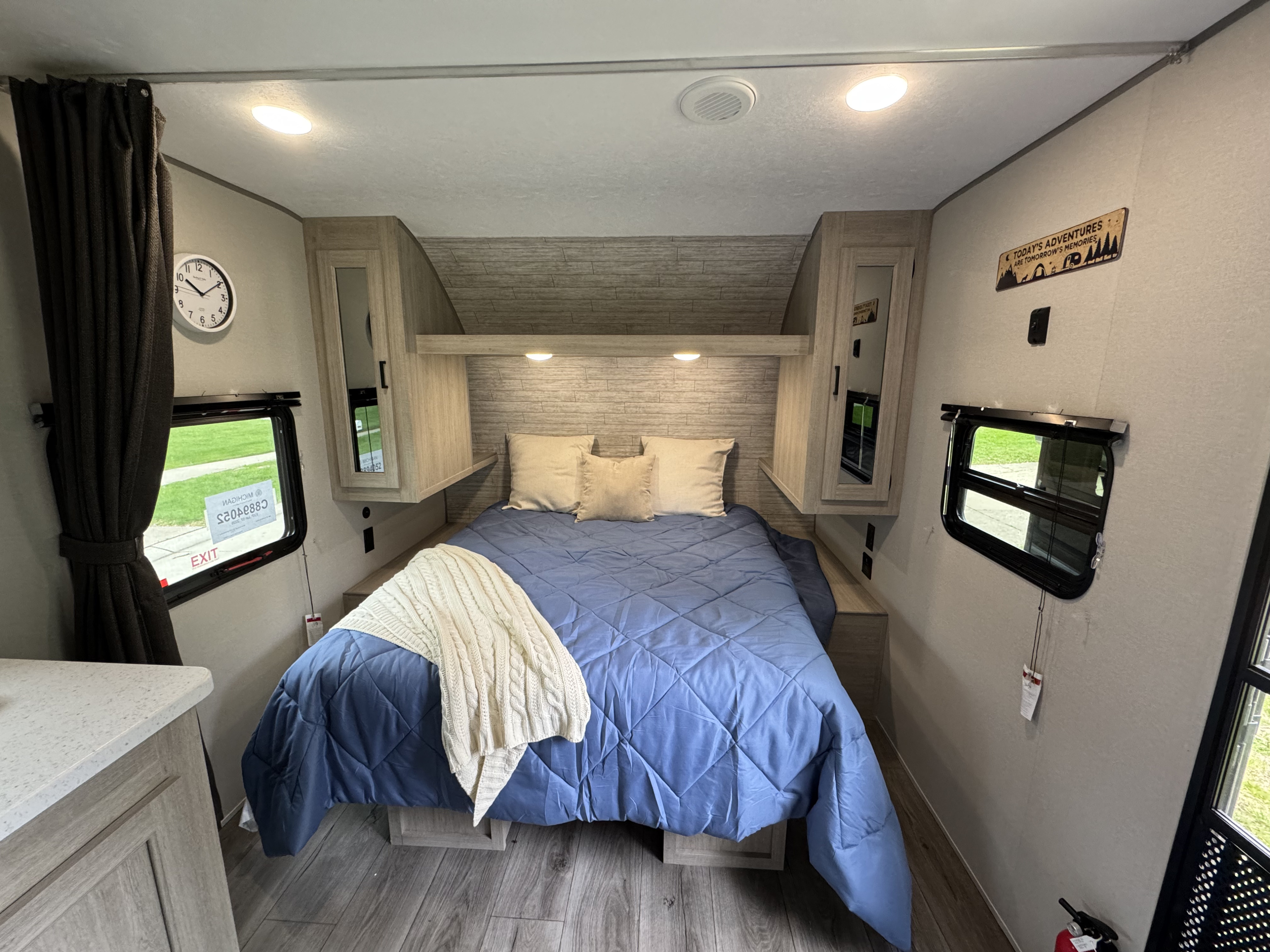 Experience comfort in this RV rental bedroom. Features a large bed with blue comforter, overhead storage, and natural light from two windows.. Coachmen Catalina Summit Series 8 2026