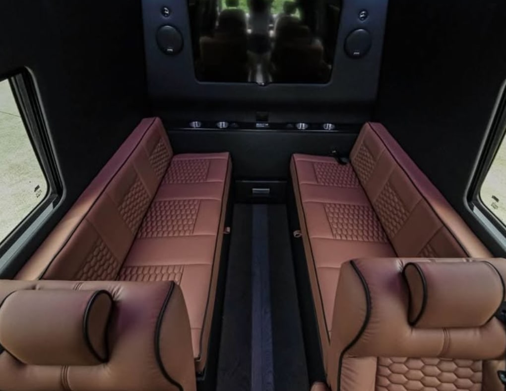 Luxury RV rental interior: opposing brown quilted seats, a rear screen, and side windows for premium travel comfort.. Mercedes Benz Executive Lounger by Legends Sprinter 3500xd 170 Ext AWD Executive Lounger 2023