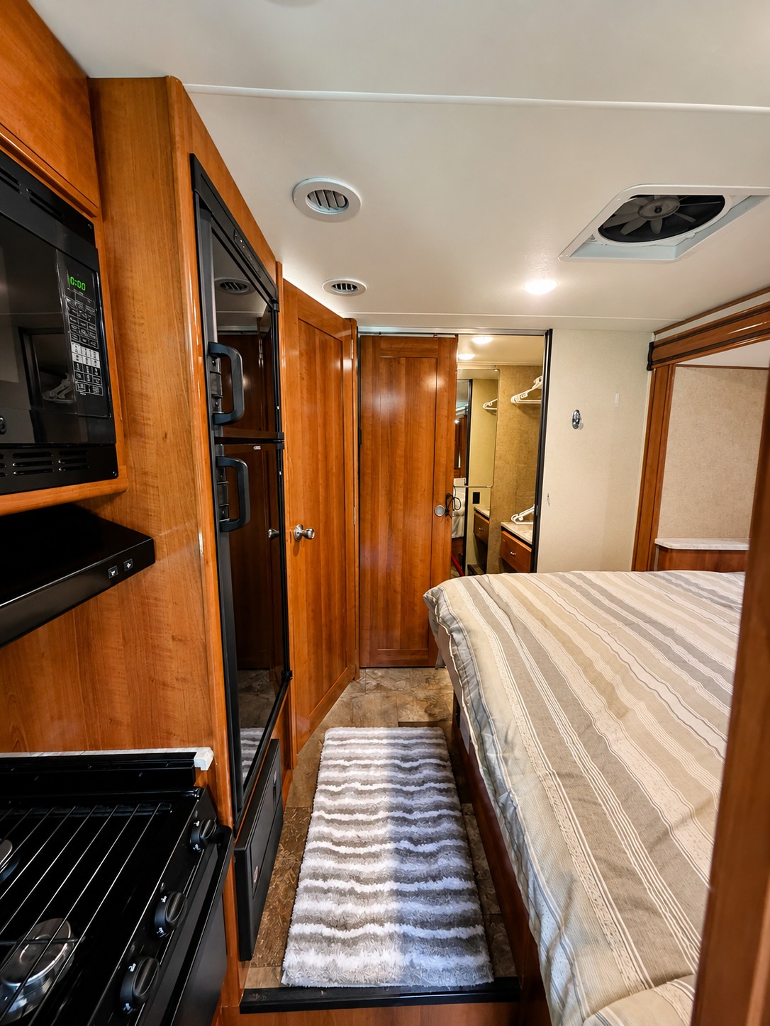 Well-appointed rv rental interior showcasing a kitchen with microwave & stove, refrigerator, bedroom, and bathroom.. Coachmen 240 2018
