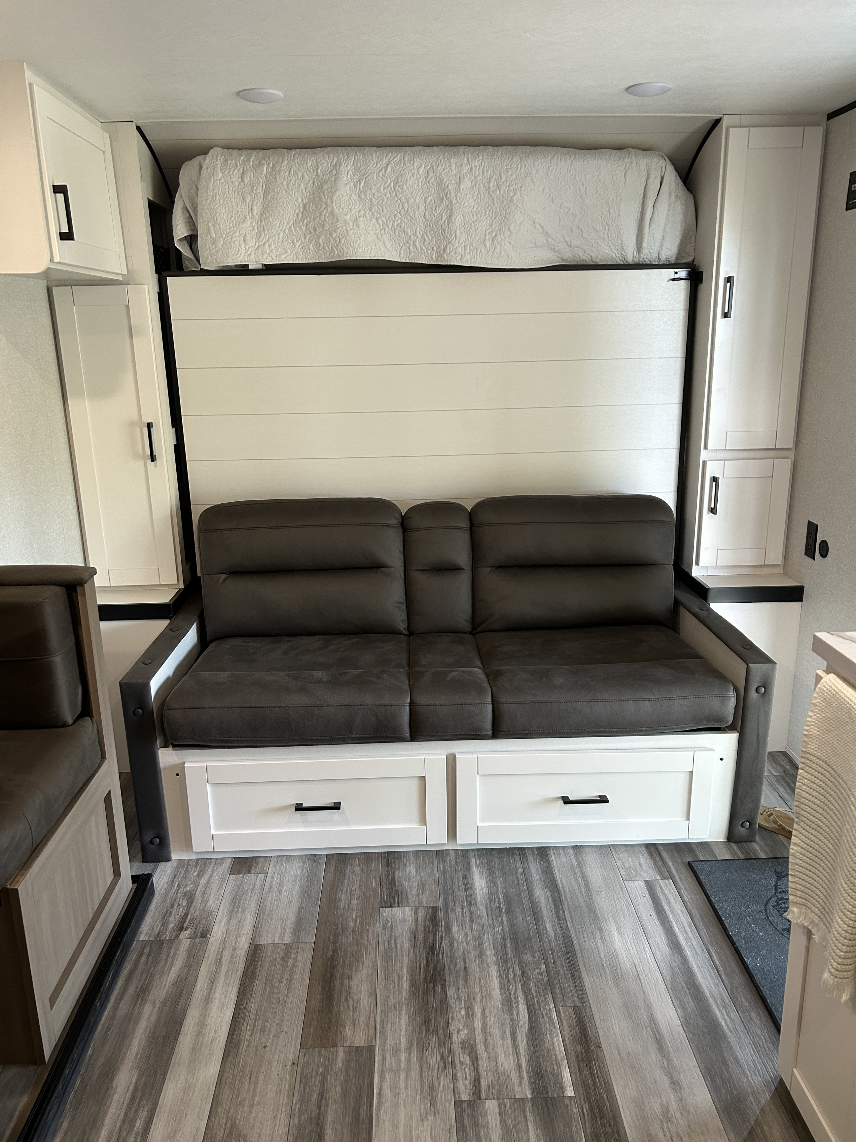 Cozy RV rental features a cleverly designed murphy bed over a sofa, with storage on sides & modern flooring.. Jayco Jay Flight SLX 2026