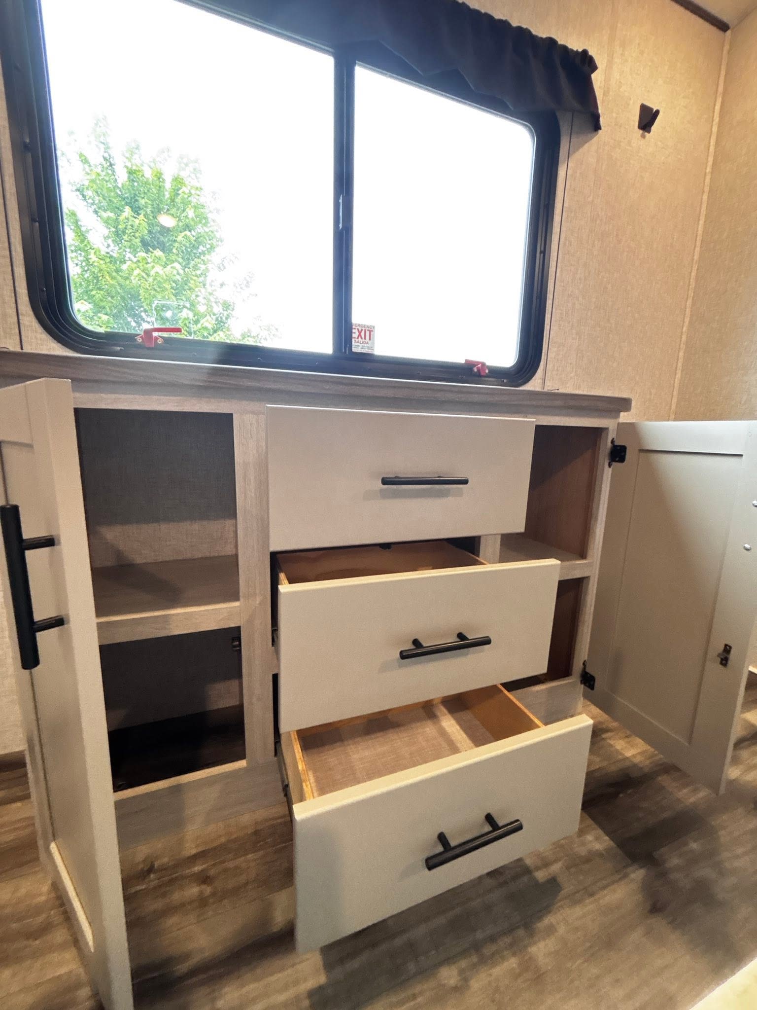 RV rental interior with open drawers & shelves for storage, and an emergency exit window visible above.. Crossroads RV Sunset Trail Super Lite 2024
