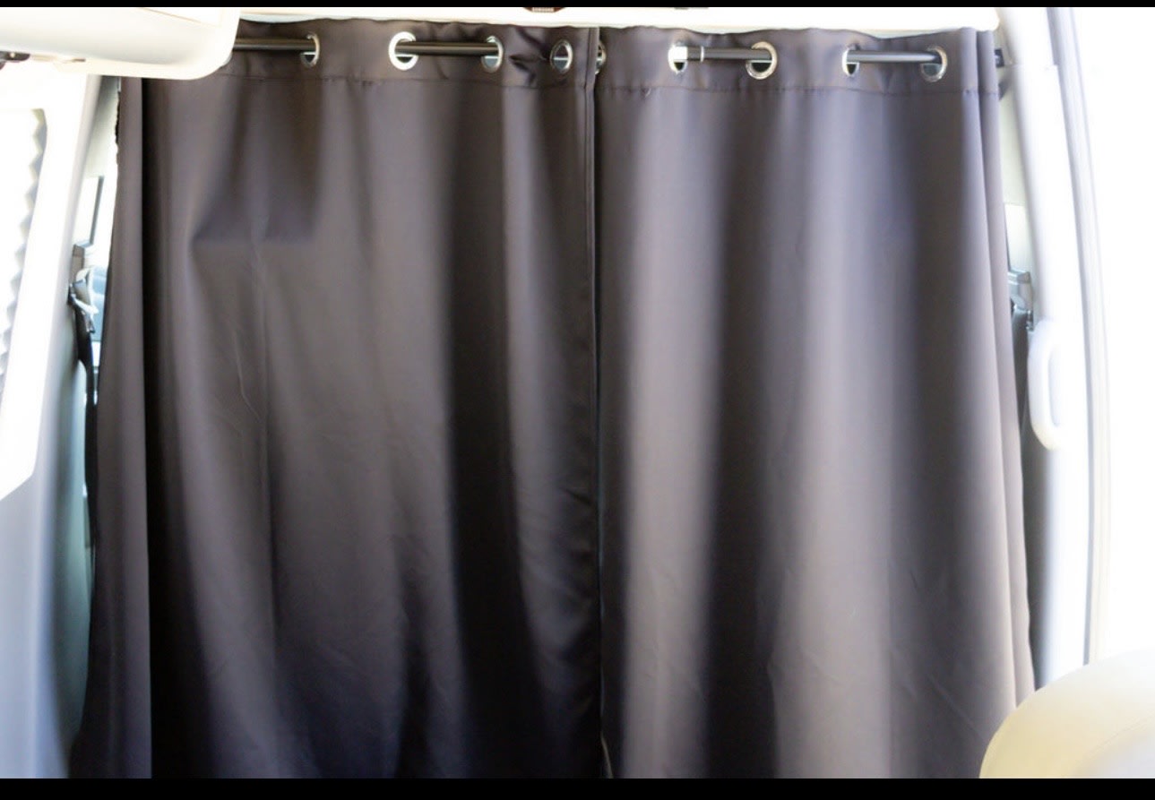 Interior of an RV rental: dark gray privacy curtains with metal grommets on a rod, providing separation and privacy.. Airstream Interstate 2014
