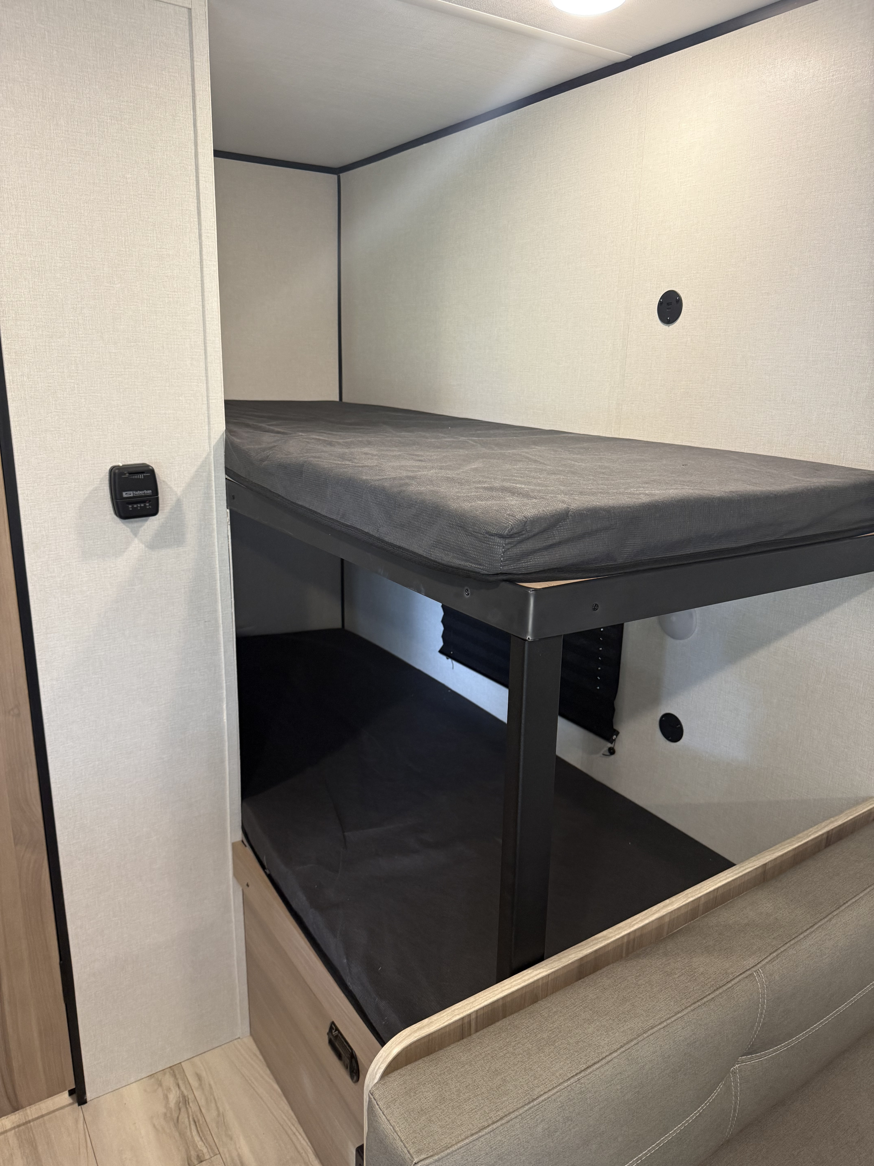 Cozy RV rental bunk beds, featuring a thermostat and USB charging port for camper comfort.. Keystone RV Coleman 2025