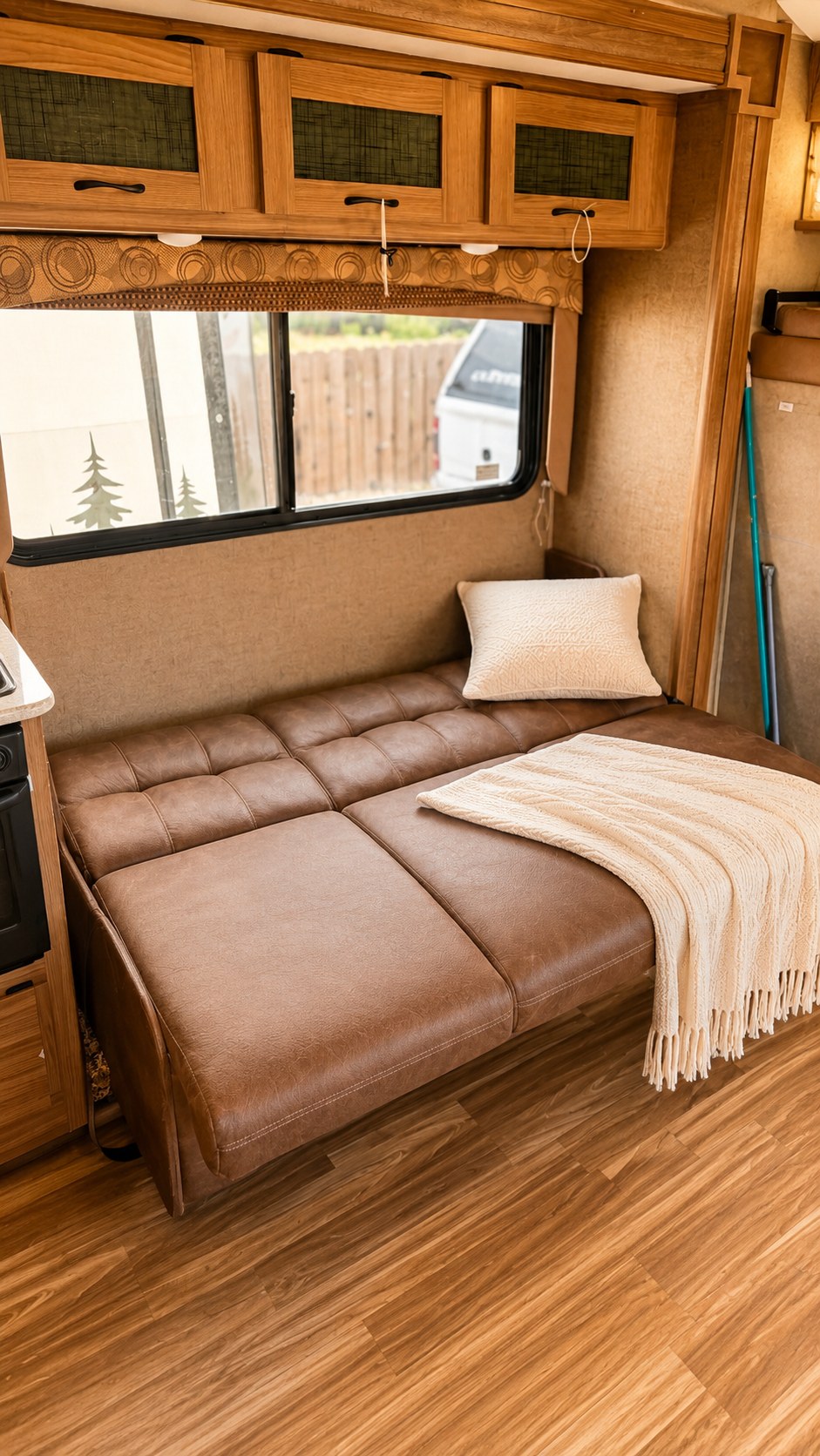 Cozy RV rental interior featuring a comfortable brown sofa bed with a blanket and pillow, ideal for relaxing trips.. Coachman Freelander 2016