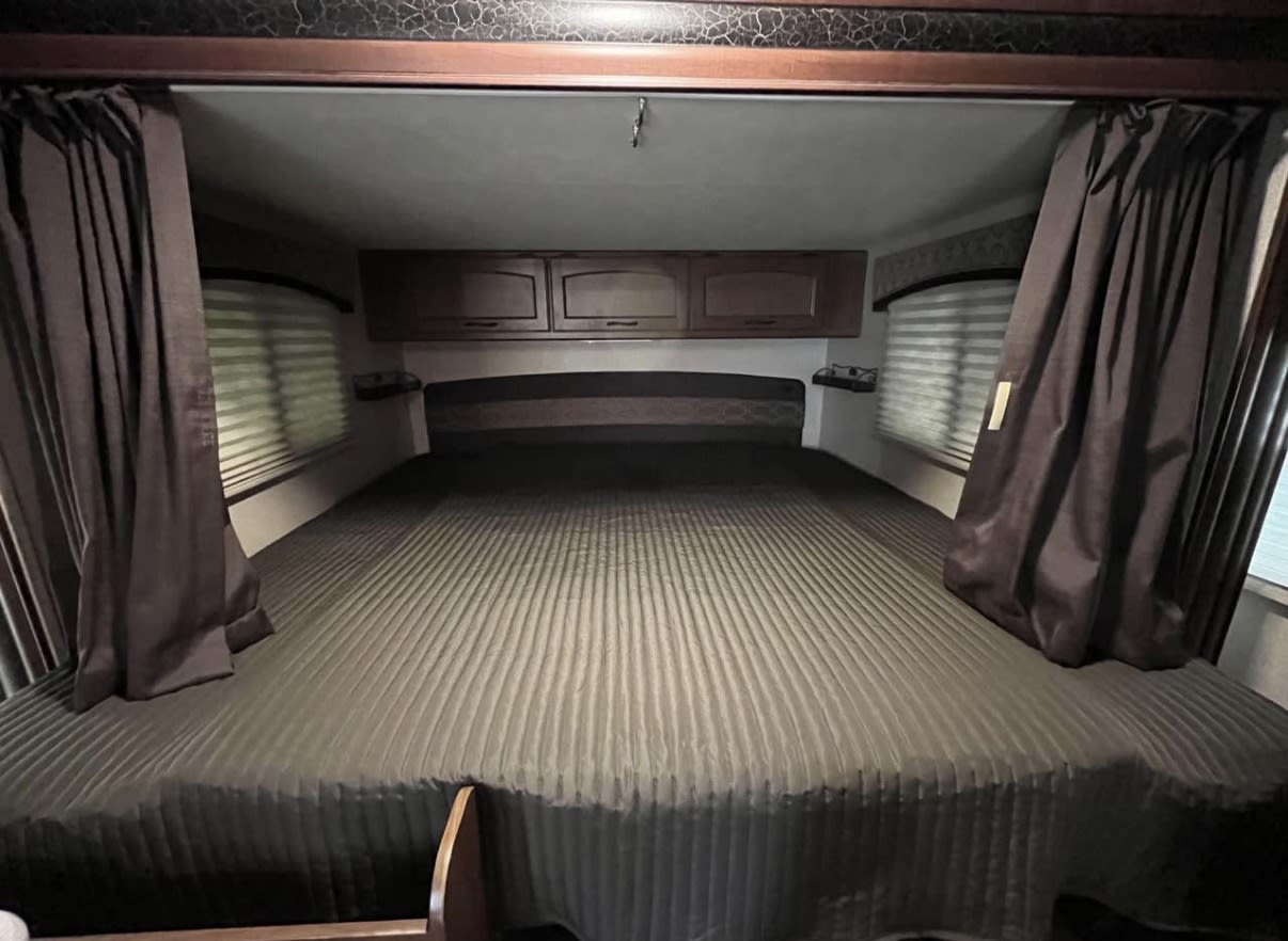 This RV rental bedroom offers a large, comfortable bed, overhead storage, and window privacy curtains and blinds.. Jayco Jay Feather Ultra Lite 2015