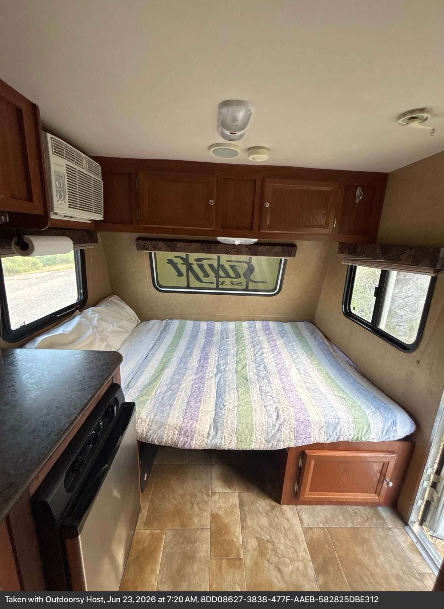 Cozy RV rental interior featuring a comfortable bed, windows, AC, and kitchenette area, ideal for road trips.. Jayco Jay Flight Swift SLX 2013