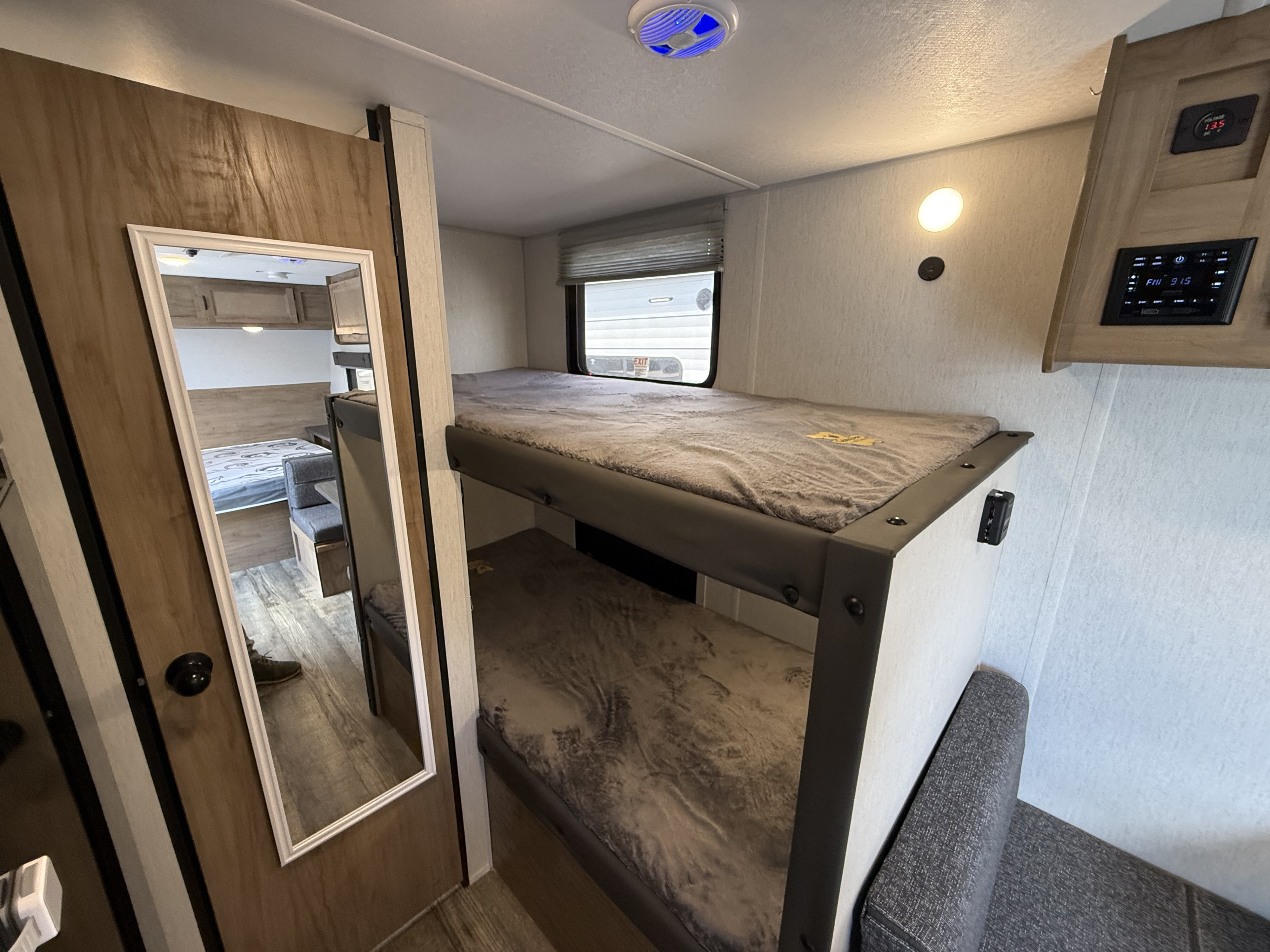 Inside an RV rental showing cozy bunk beds, main sleeping area, and control panel for family travel accommodation.. Forest River Cherokee Wolf Pup 2024