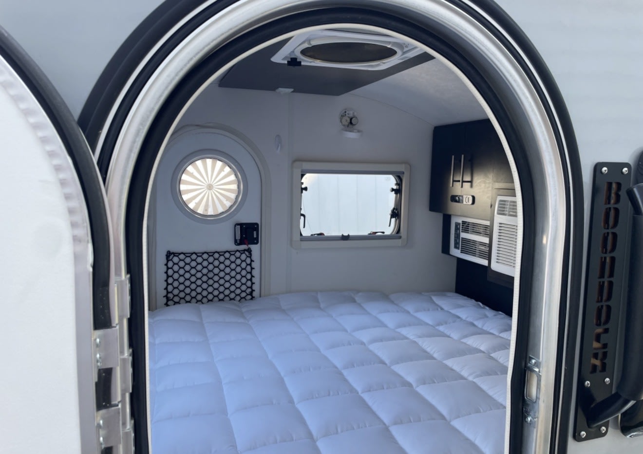 Explore this rv rental's compact interior: a comfy bed, windows, AC, and storage. Ideal for cozy travels!. nuCamp T@G 2022