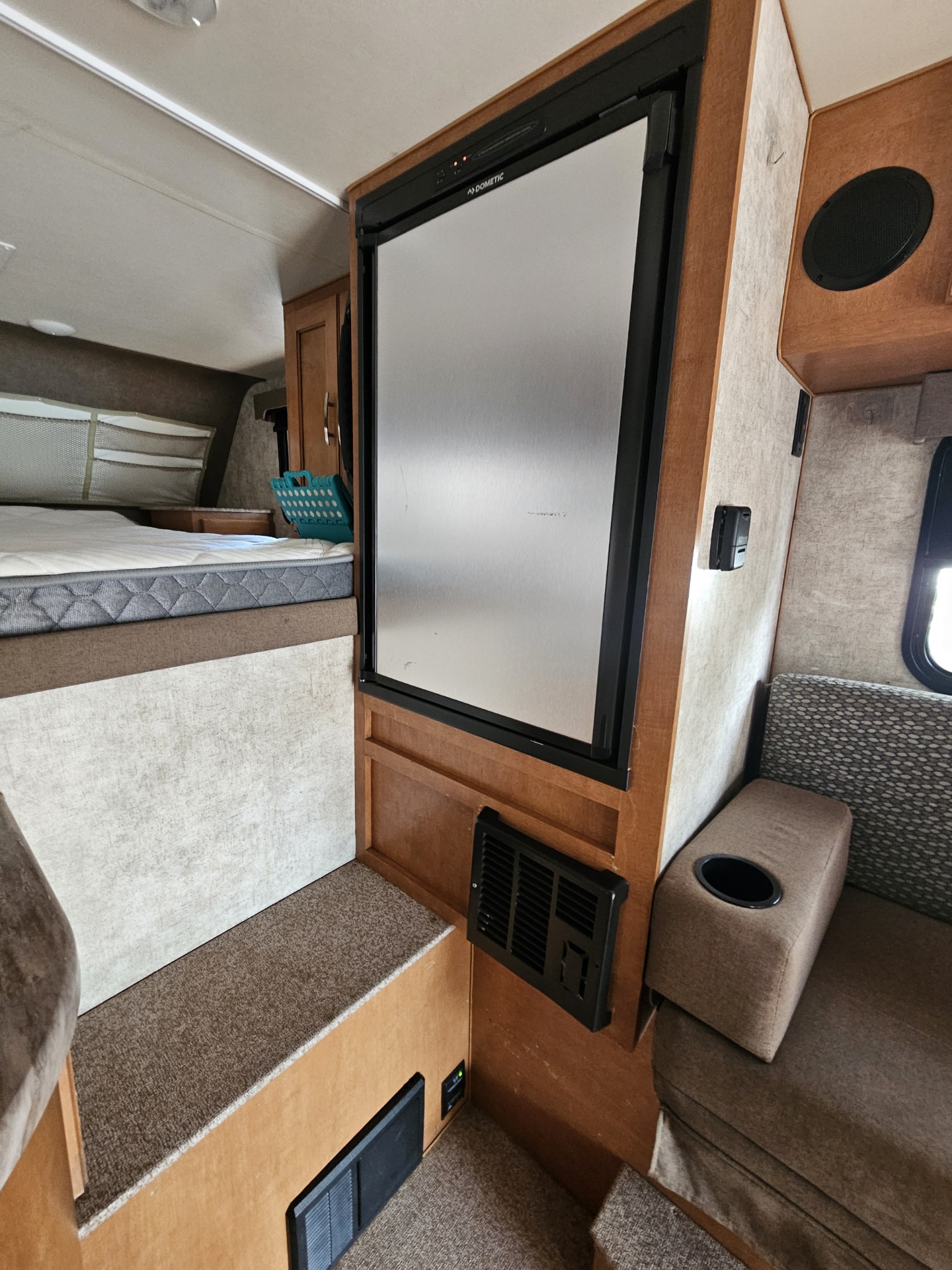 RV rental interior featuring a Dometic refrigerator, comfy bed, and cozy dinette seating for travel and adventure.. Adventurer/F150 ecoboost 80RB 2018