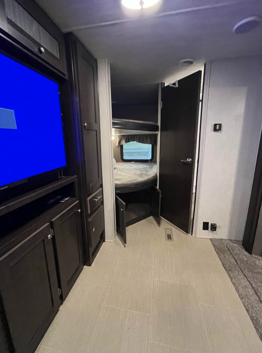 This RV rental's interior boasts dark wood cabinetry, a TV living area, and a bunkhouse with beds and under-bed storage.. Heartland RVs Prowler 2019