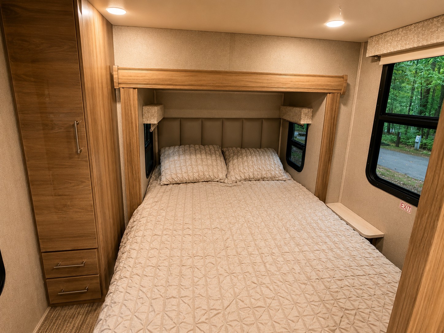 Cozy RV rental bedroom with a comfortable bed, built-in wardrobe, and window views of nature outside.. Entegra Coach Qwest 2019