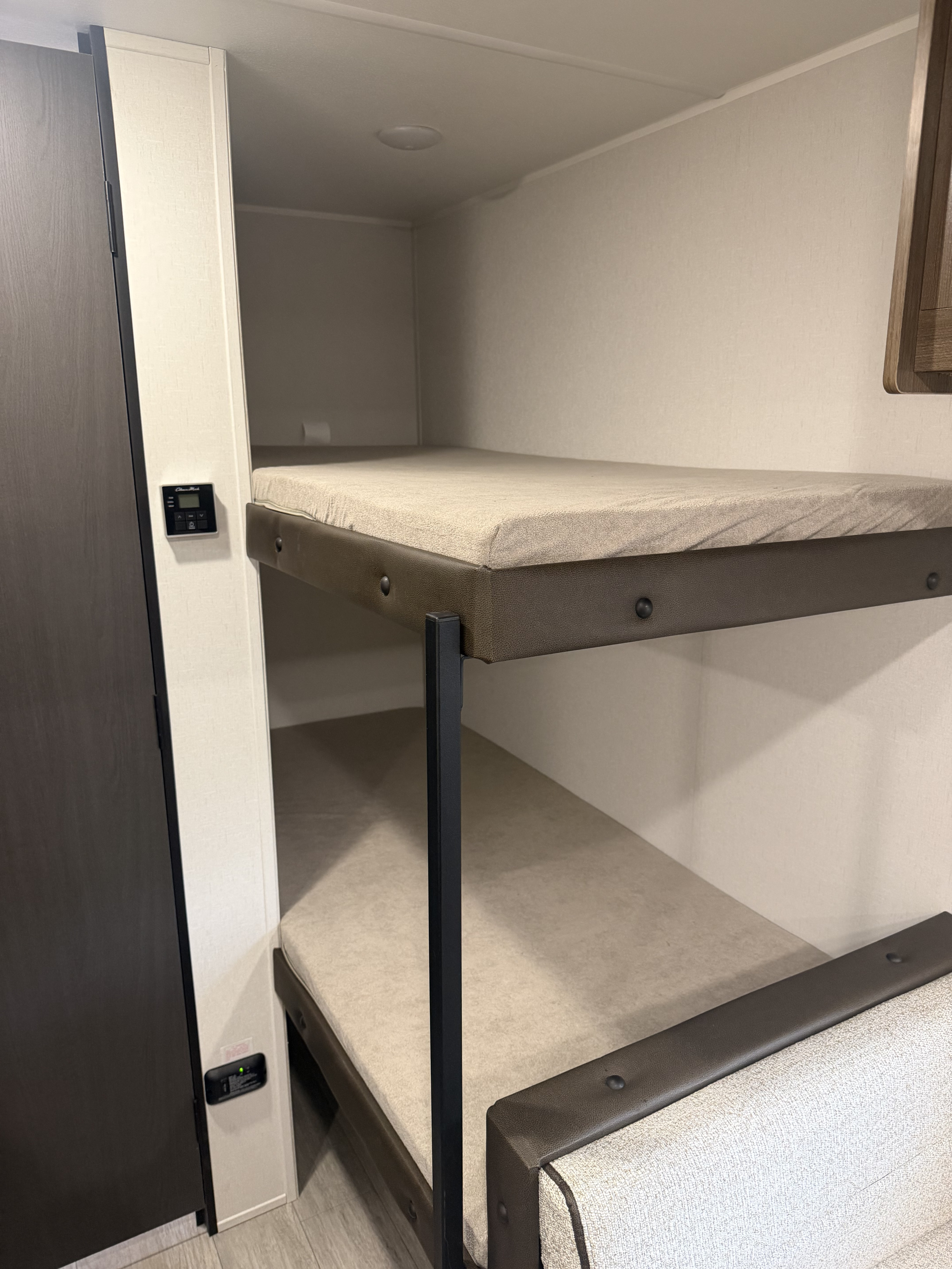 Compact bunk beds in an RV rental, featuring a thermostat and CO detector for comfortable, safe travel.. Forest River Prime Time Avenger 16bhx 2027