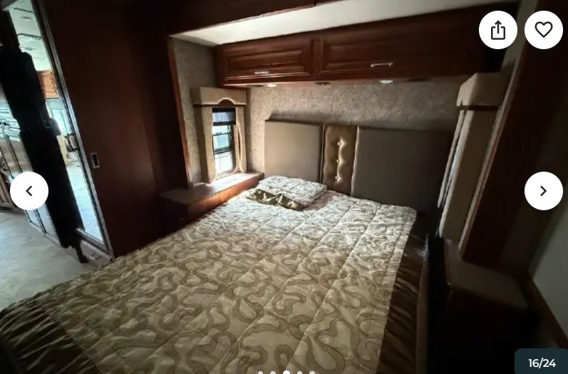 Cozy RV rental bedroom with a comfy bed, upholstered headboard, overhead storage, and window. Perfect for on-the-road travel.. Fleetwood Southwind 2015