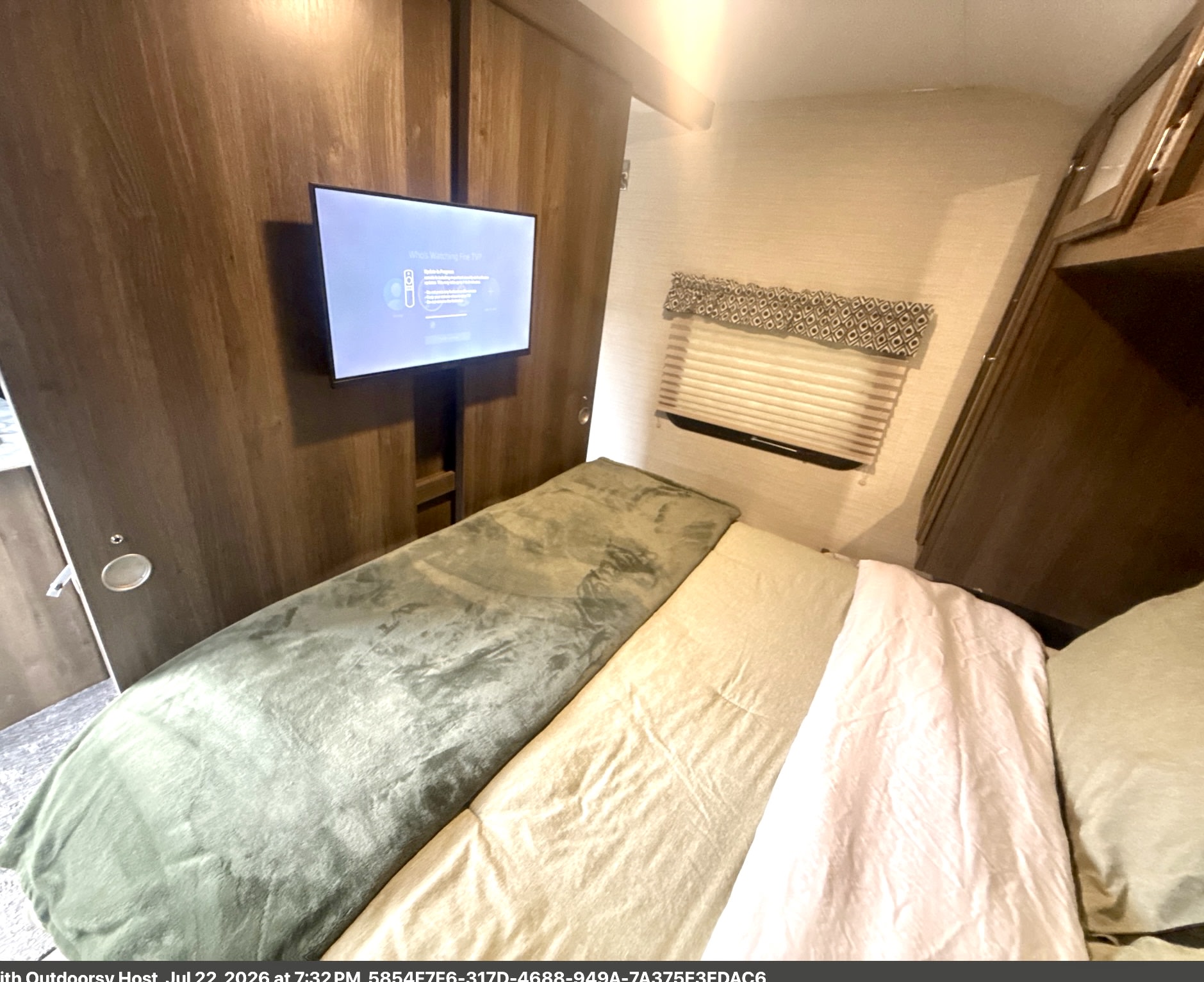 Cozy rv rental bedroom featuring a bed with soft blankets, a wall-mounted TV displaying "Fire TV," and a window with blinds.. Keystone RV Bullet Ultra Lite 2018