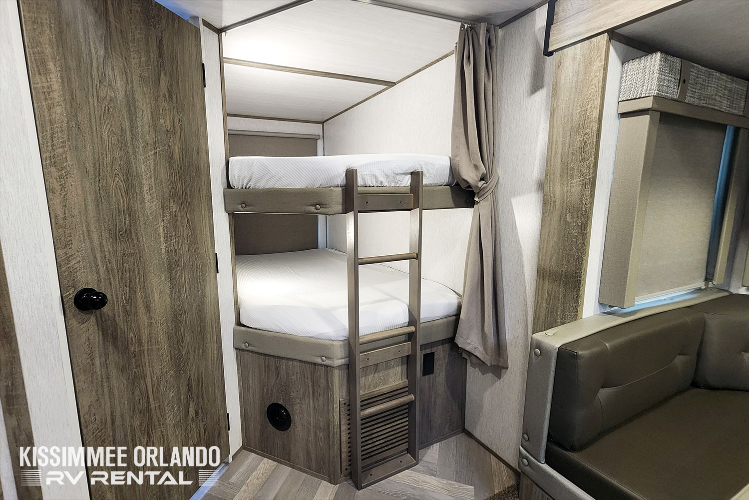 Cozy RV rental interior with bunk beds, a ladder, and a seating area, ideal for family travel in a compact space.. Forest River Salem Hemisphere HL 2022