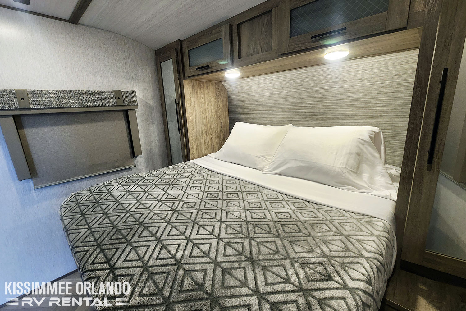 Relaxing RV rental bedroom with a geometric patterned blanket, overhead storage, and window. Ideal for trips.. Forest River Salem Hemisphere HL 2022