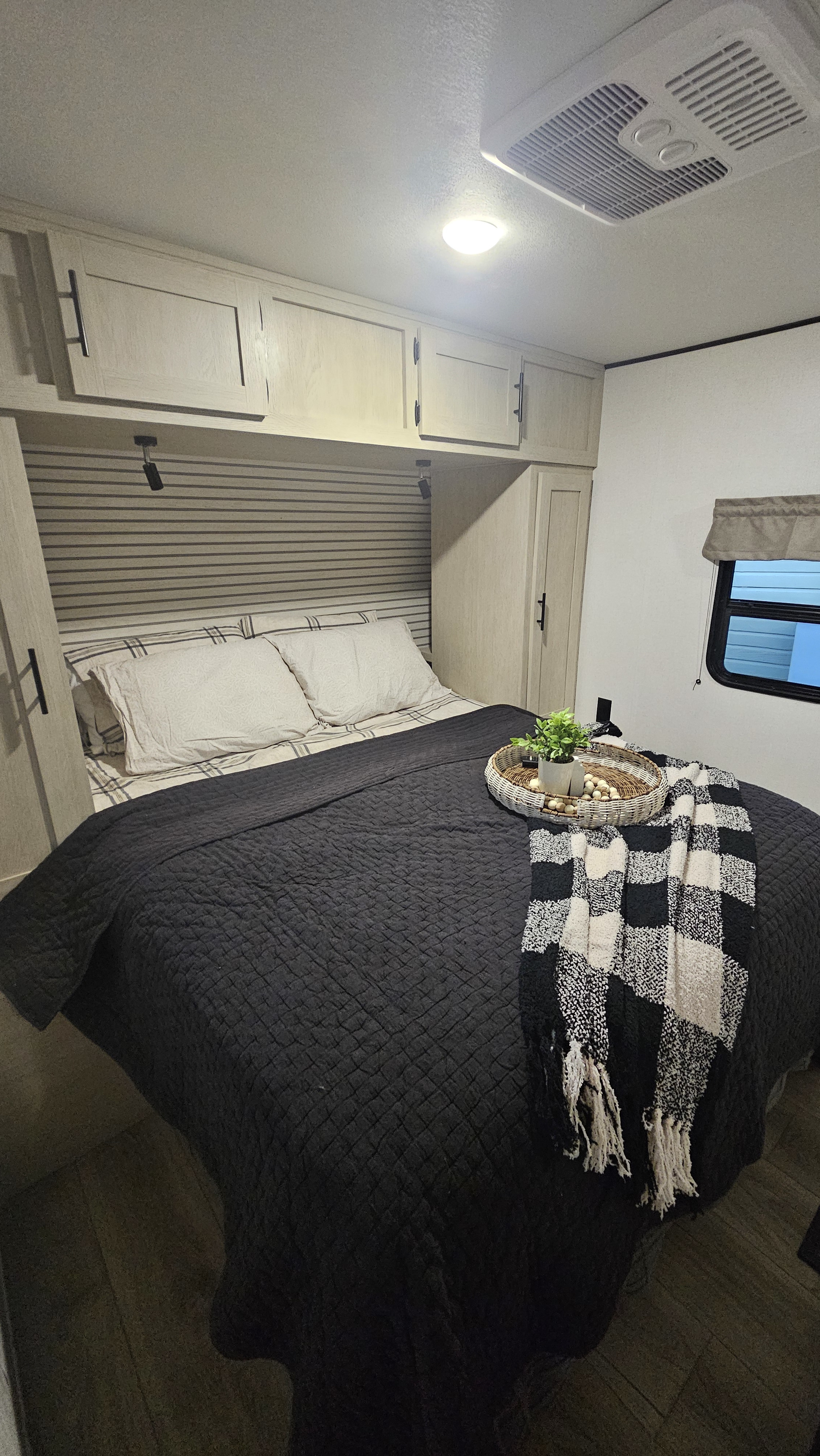 Cozy RV rental bedroom with a comfortable bed, overhead storage, and a window for natural light.. Forest River Shasta I-5 2025