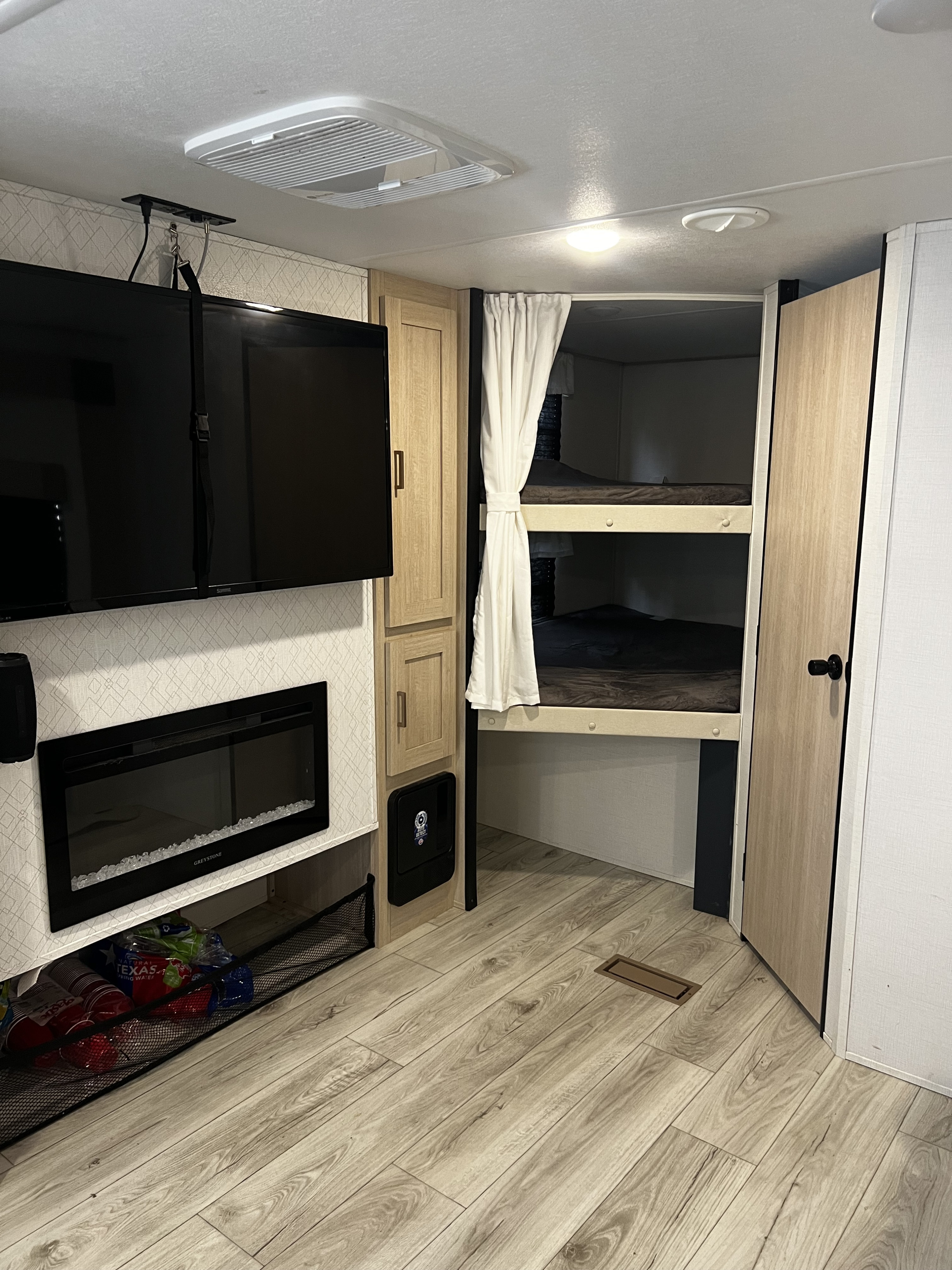 RV rental interior featuring cozy bunk beds, entertainment setup (TV, fireplace), and ample storage.. Avenger Avenger Trailer 2025