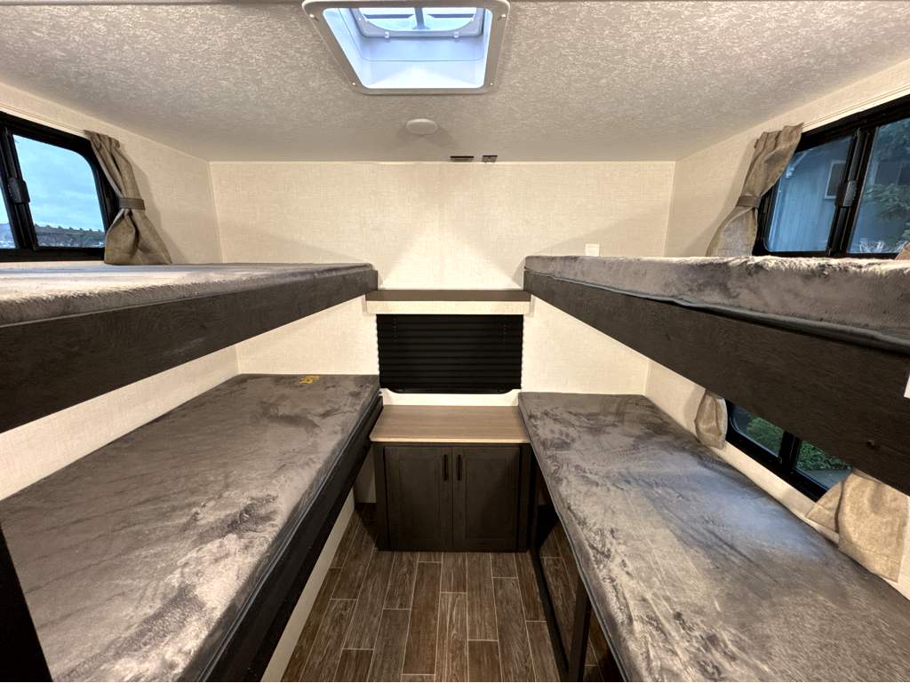Spacious RV rental bunk beds with four comfy sleeping areas, windows, and central storage. Ideal for family camper trips.. Sienna SA281VQB 2025