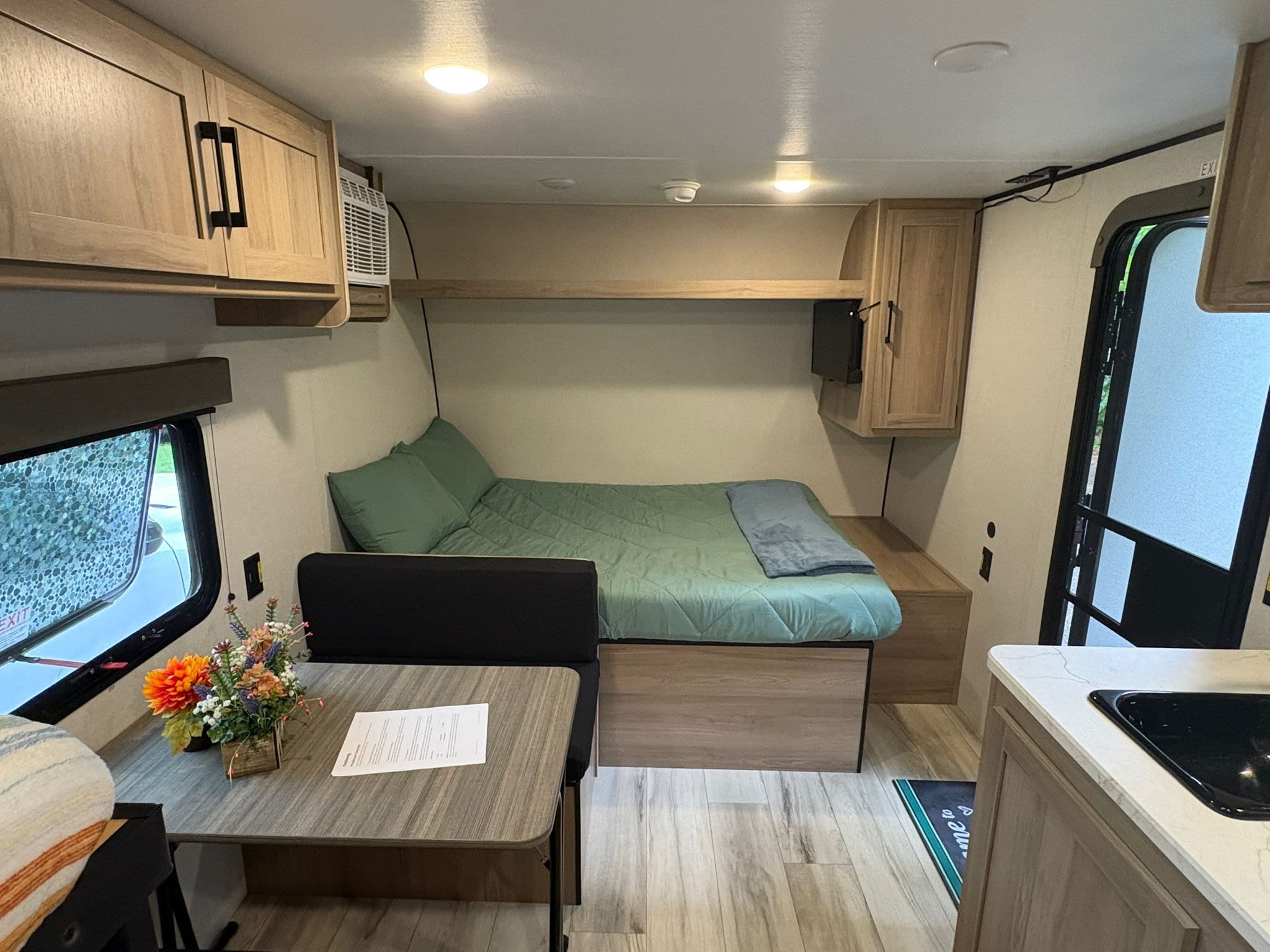 Cozy RV rental interior: comfortable bed, dinette, and compact kitchen. Perfect for travel adventures.. Keystone RV Coleman 2025