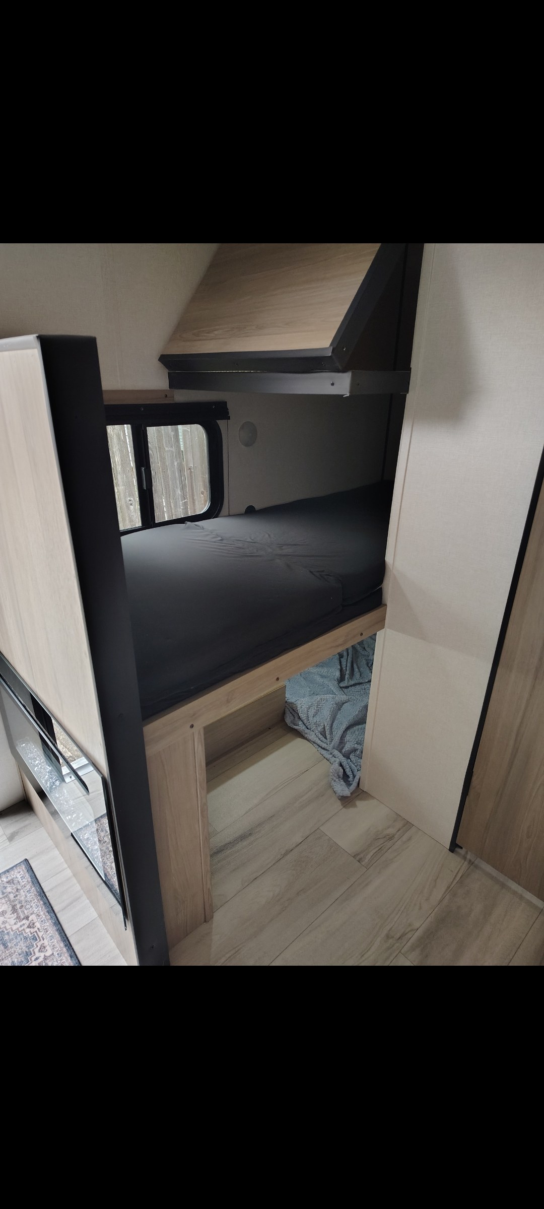 RV rental interior: modern bunk beds with a window and wood-look flooring, ideal for family trips and compact travel.. Keystone RV Coleman 2025