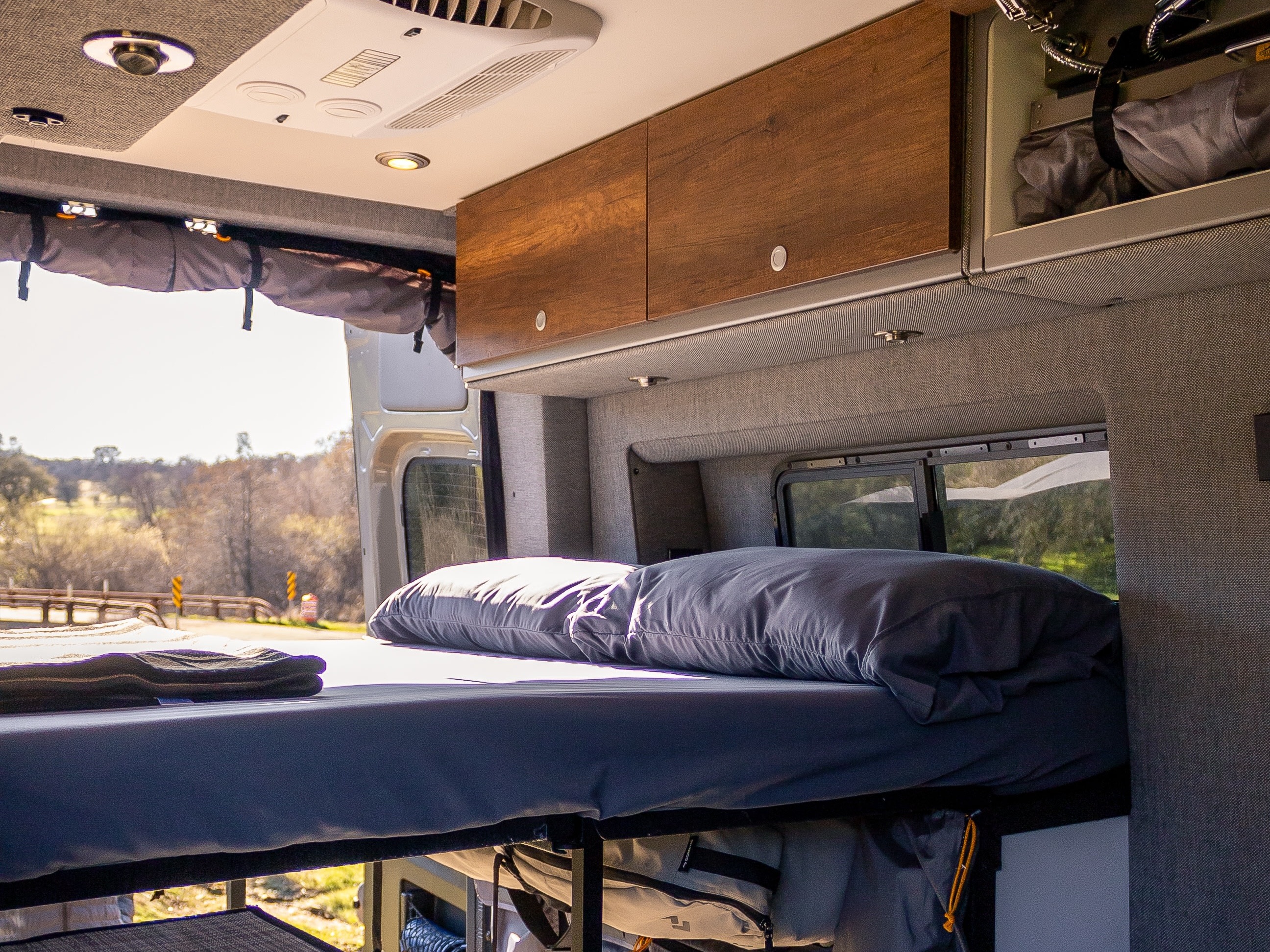 Spacious RV rental interior with bunk beds, overhead storage, and scenic views, ideal for travel and camping.. Storyteller Overland Beast MODE 2024