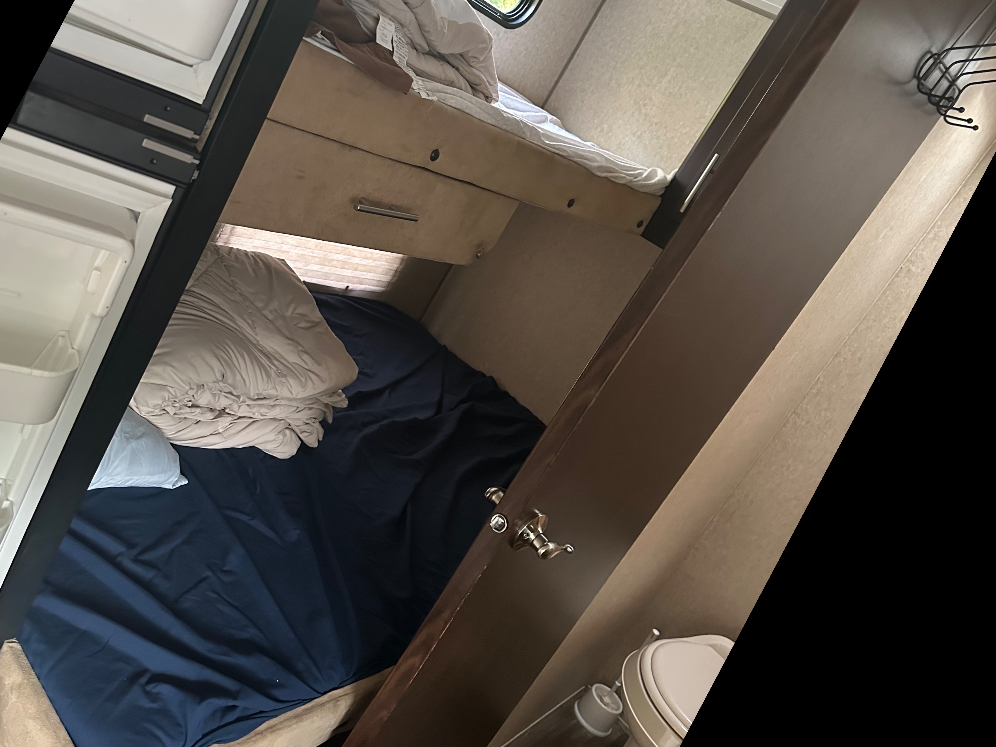 Inside this RV rental: comfortable bunk beds, a compact fridge, and a small bathroom. Ideal for family adventures.. Forest River Grey wolf 2016
