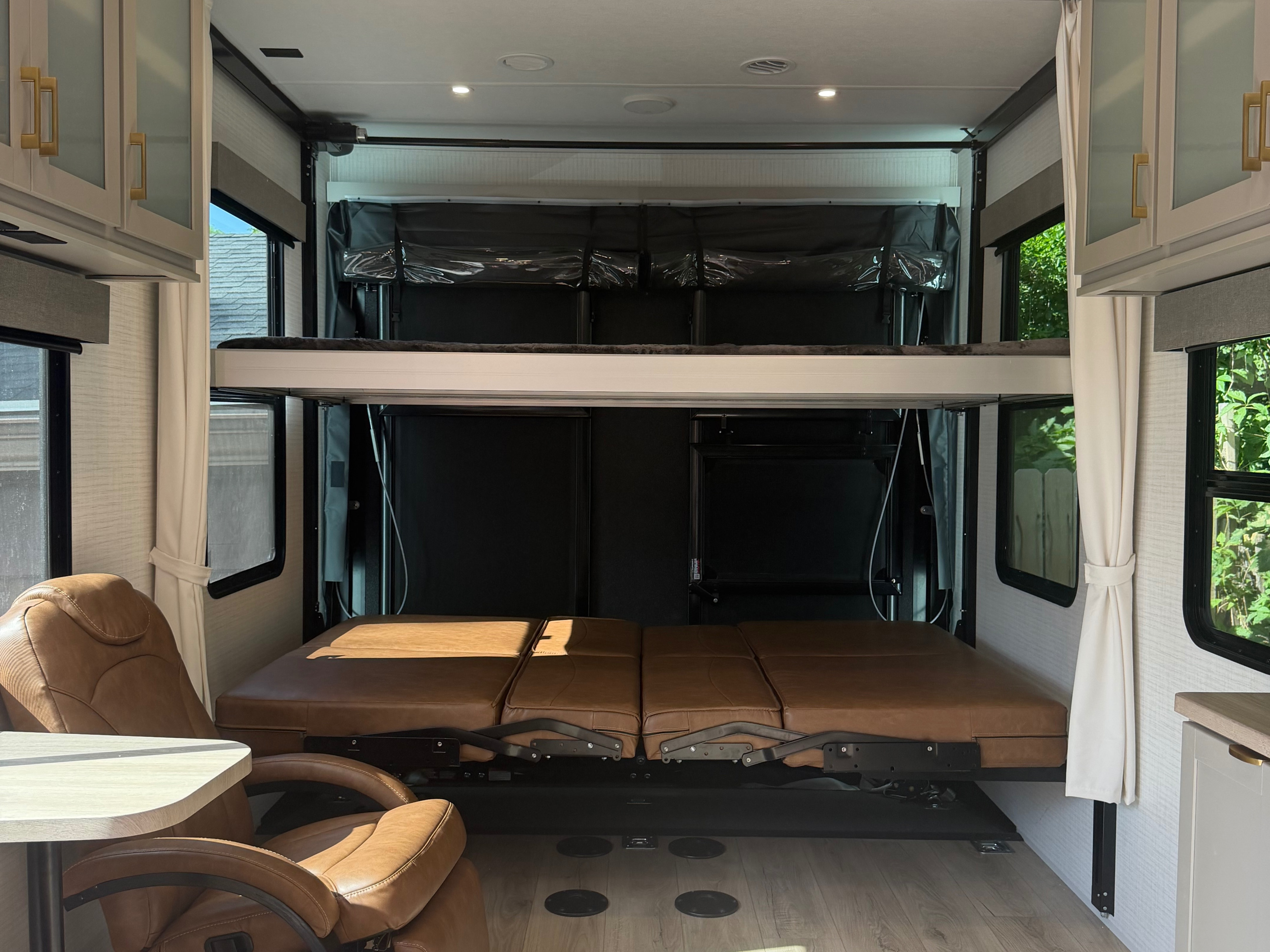 RV rental interior: A versatile space with a brown convertible seating area below an overhead bunk bed.. Forest River Stealth 2026