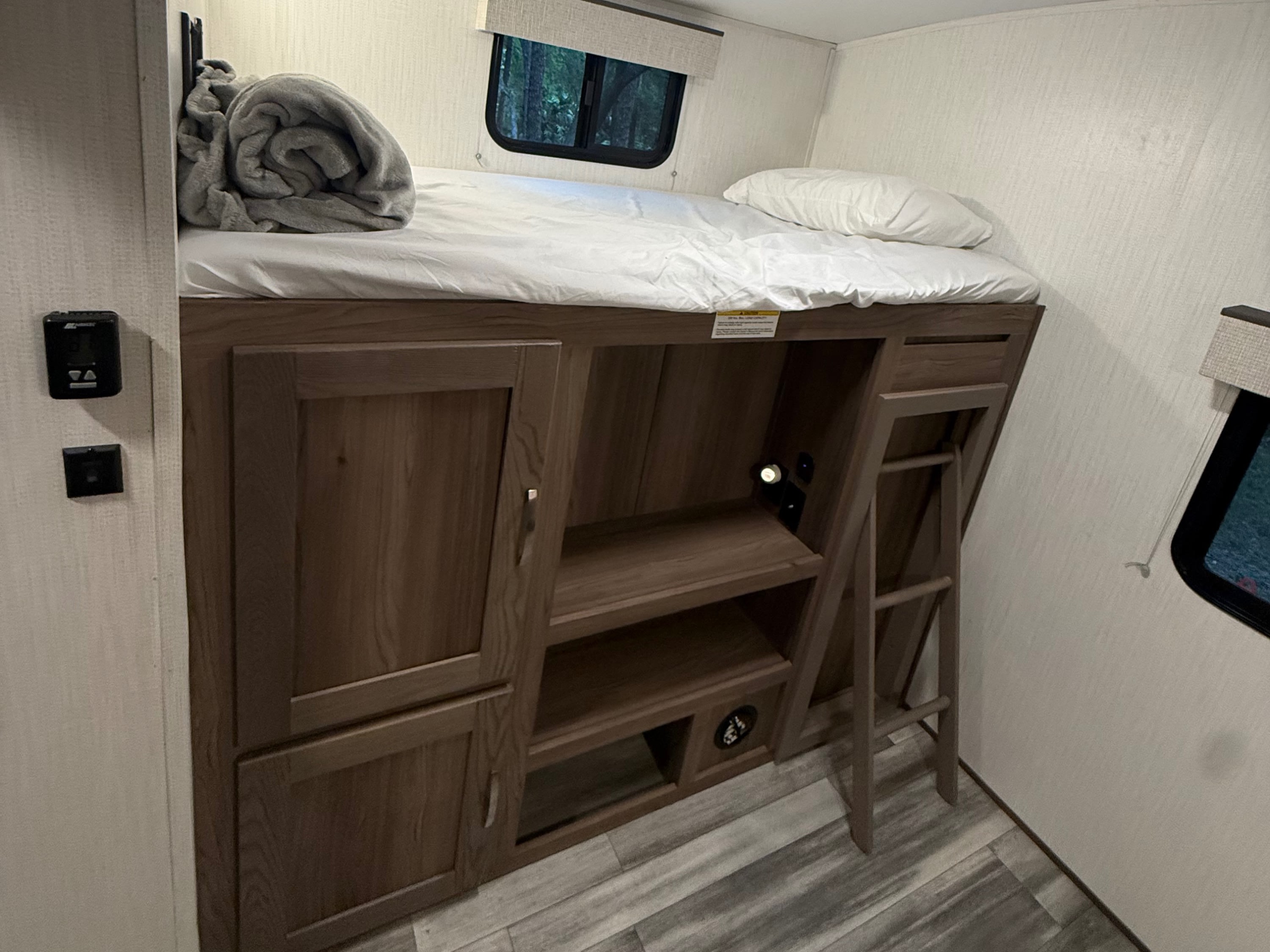 Inside this rv rental: a bunk bed with a ladder, built-in storage, a window, and overhead AC unit.. Twilight RVS Signature 2023