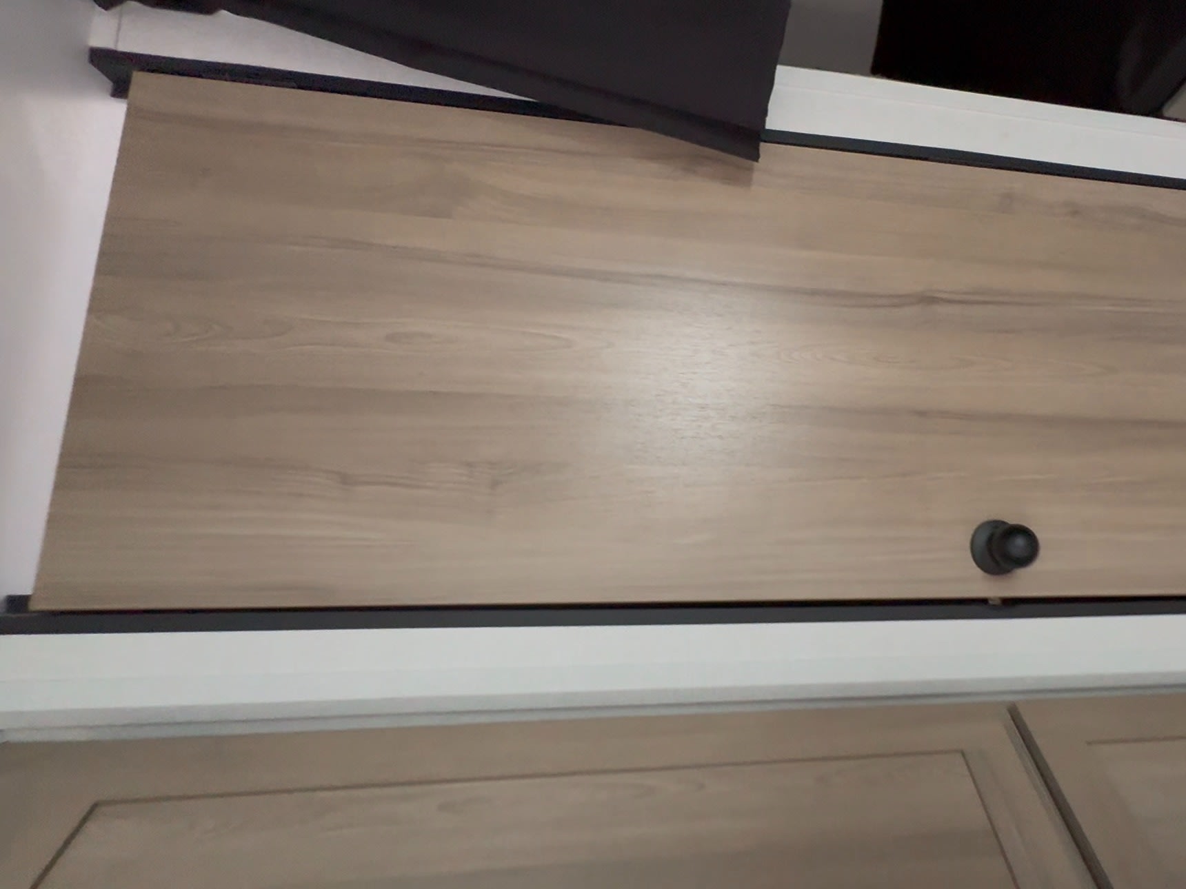 RV rental interior: Wood-grain door with black knob. Next to a compact sleeping/storage area.. Coleman Light 26BX 2025