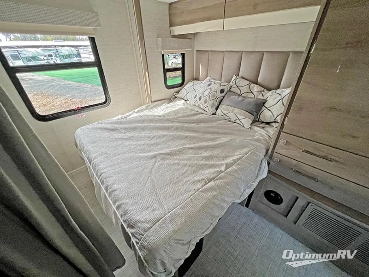 Step into the cozy bedroom of this RV rental, featuring a comfortable bed, storage, and a scenic window view.. Entegra Coach Qwest 2018